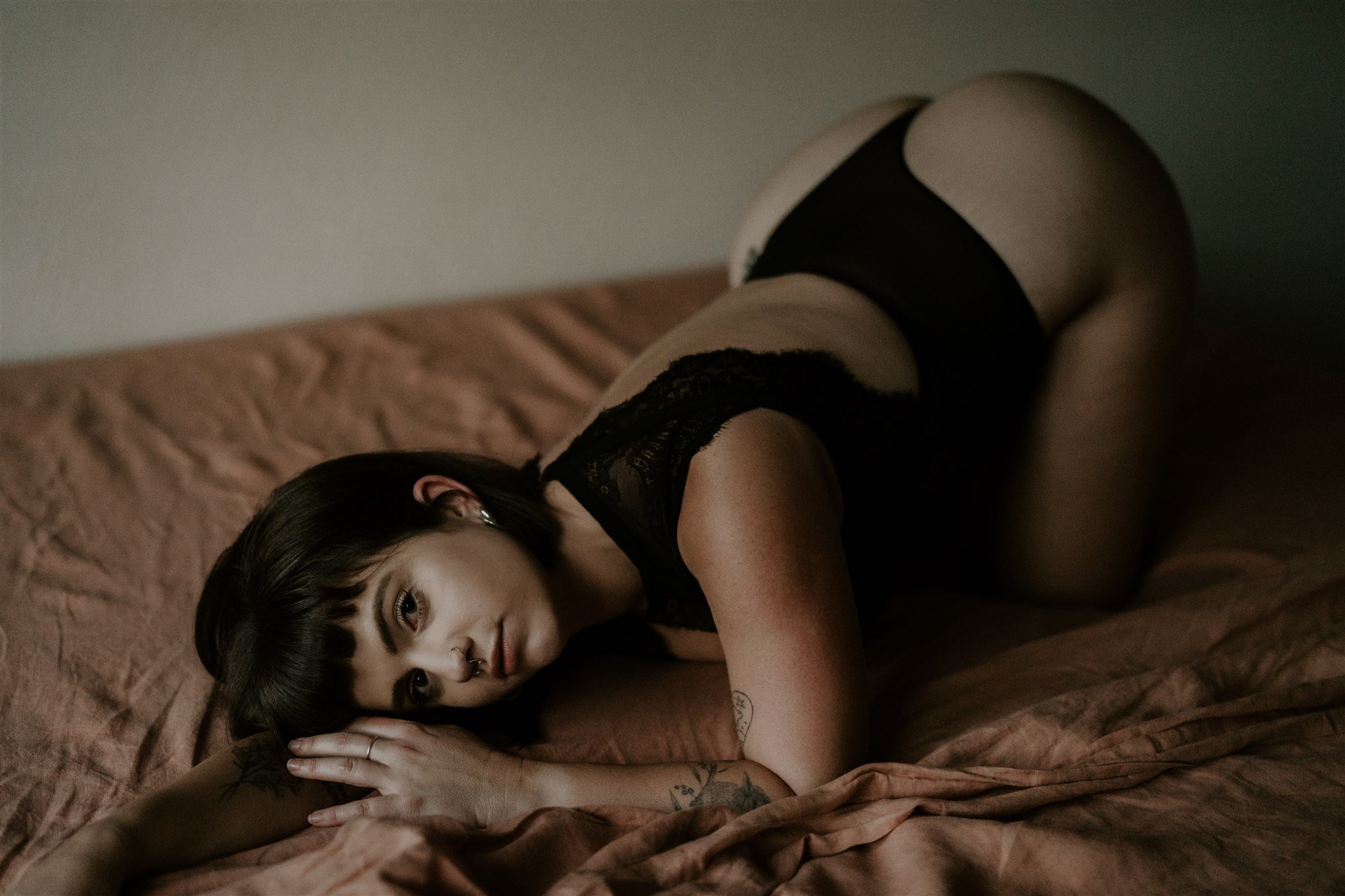 woman in lingerie lying on bed looking at camera