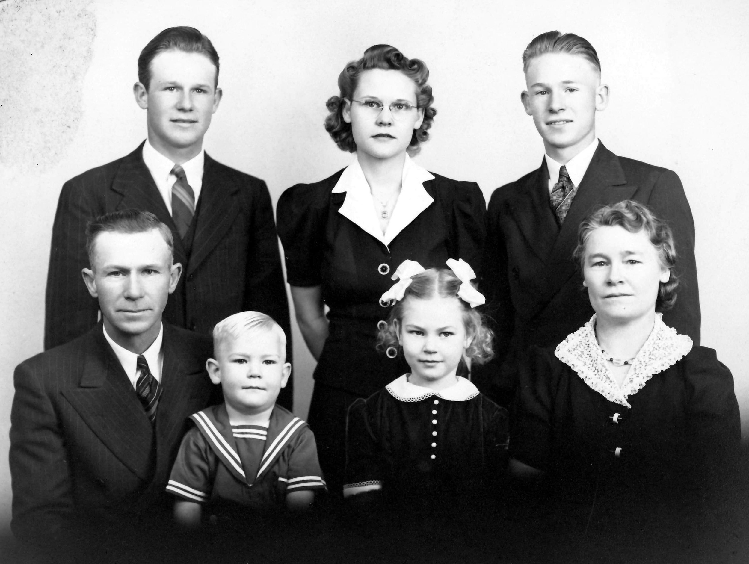 Black and white family portrait with two parents and five children of various ages.