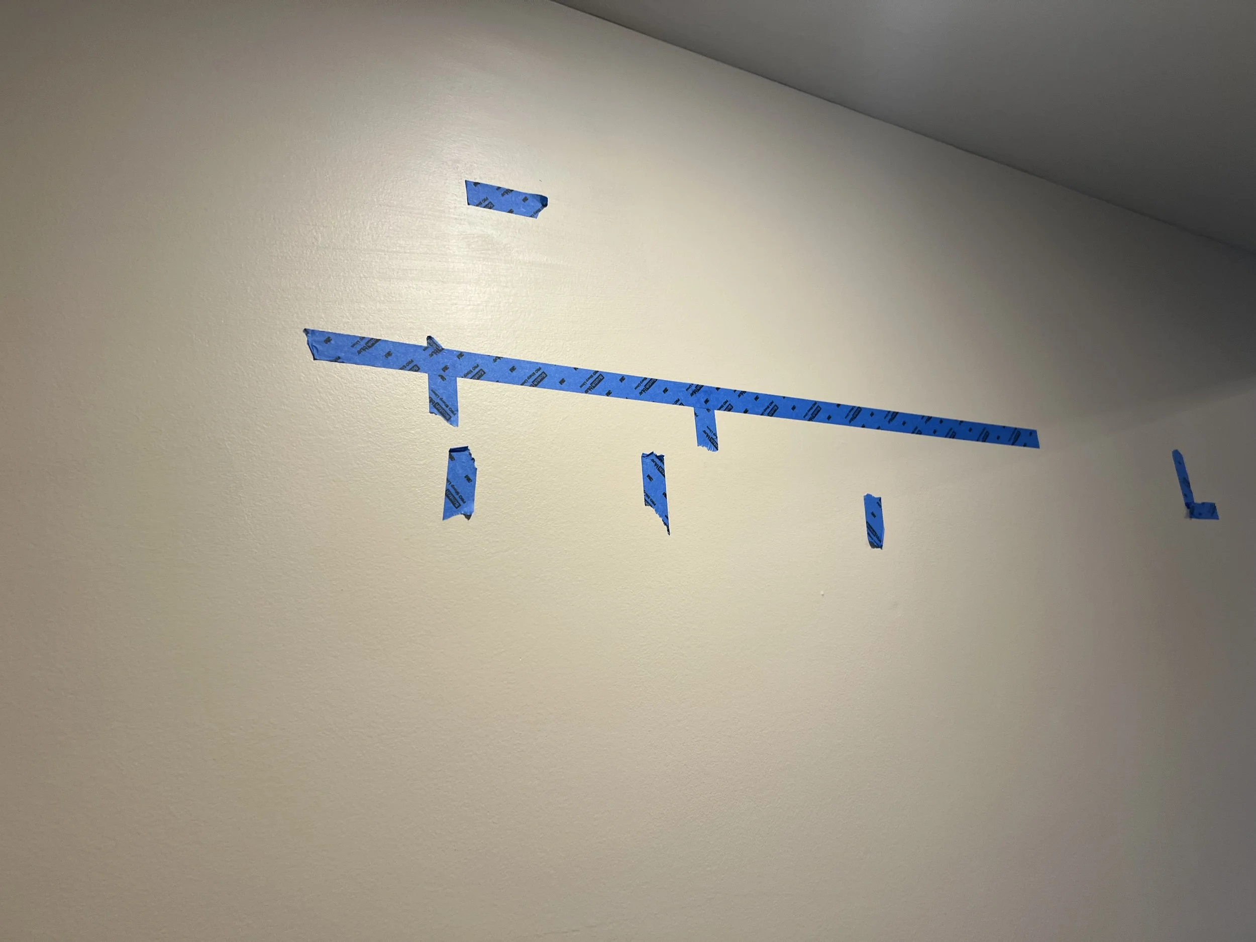 Blue painter's tape on a beige wall