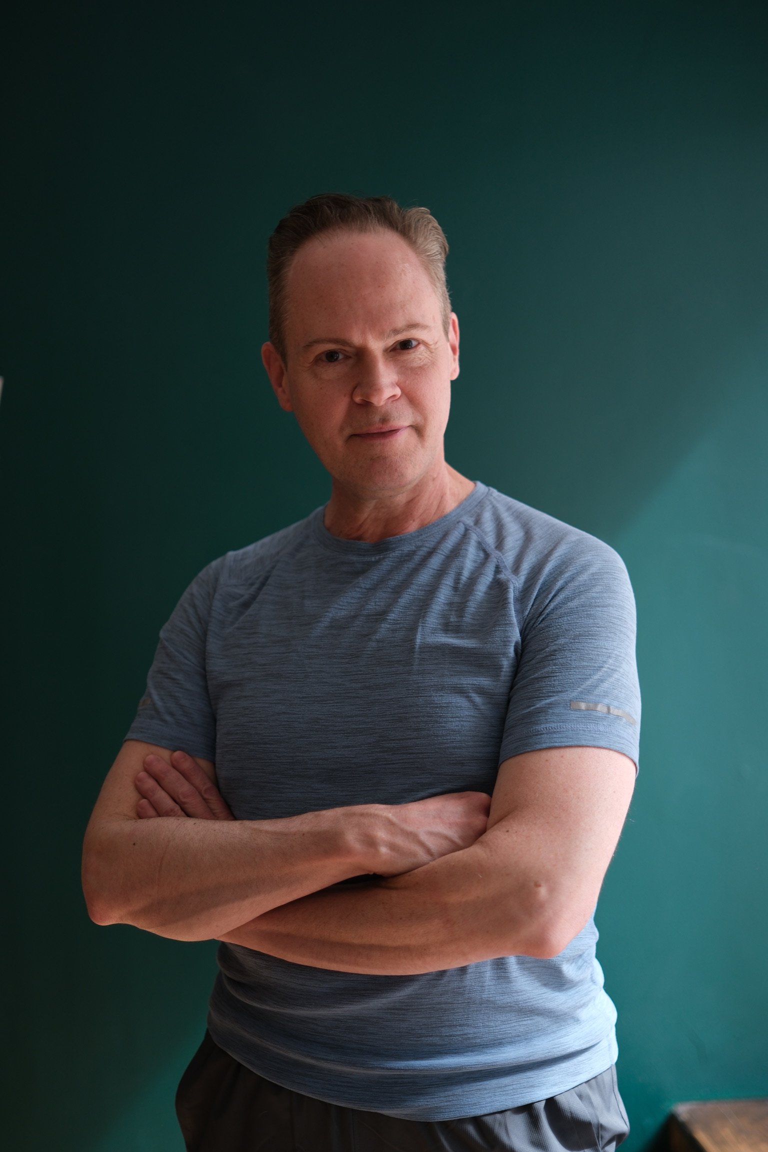 Dan Weltner, Pilates instructor at Hell's Kitchen Pilates, standing with arms crossed