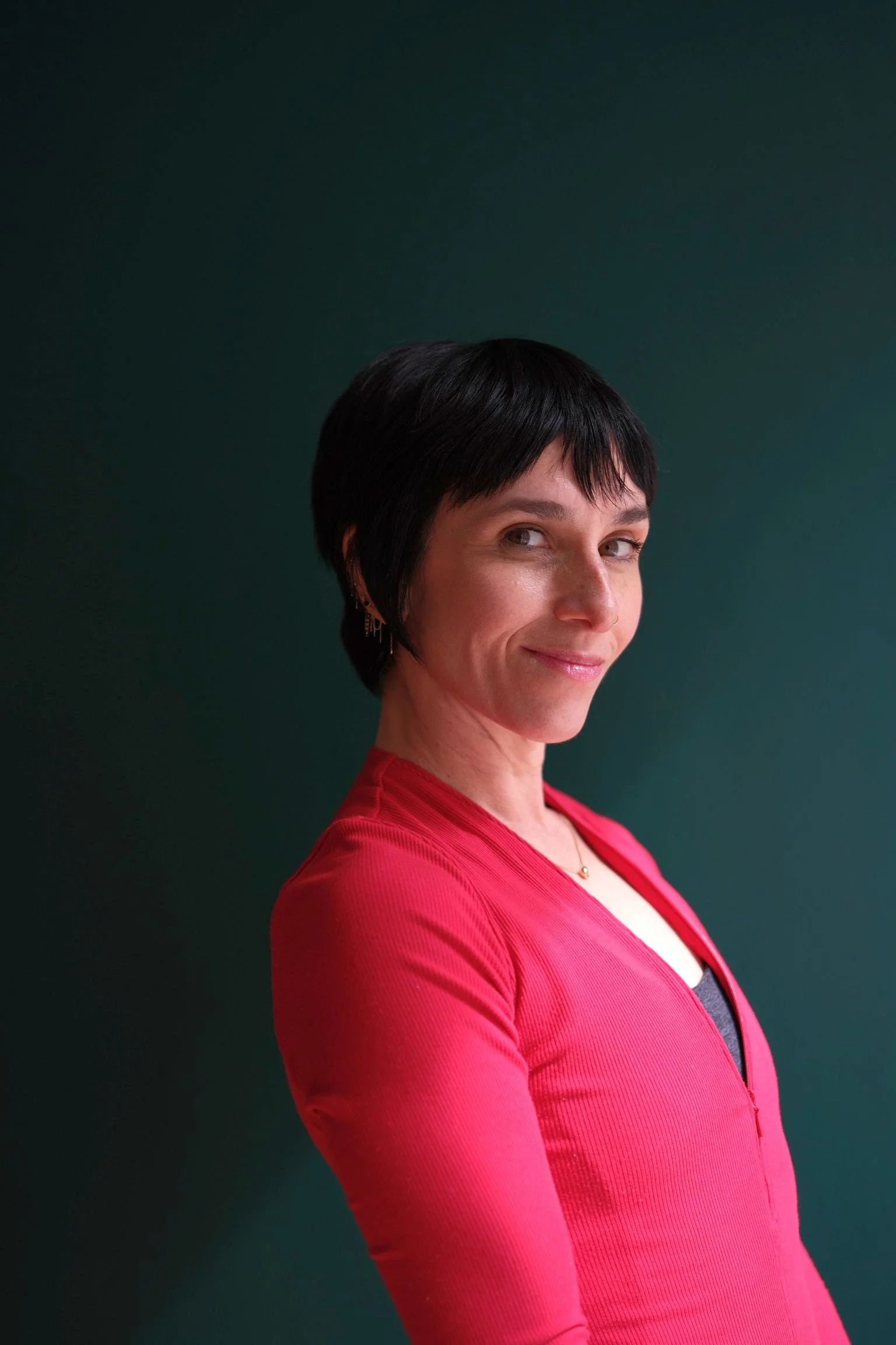 Heather Giesa, Pilates instructor at Hell's Kitchen Pilates, wearing a red top and smiling