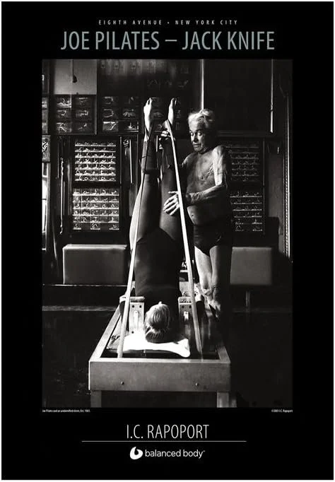 Joseph Pilates demonstrating the Jack Knife exercise on the Reformer at his New York City studio