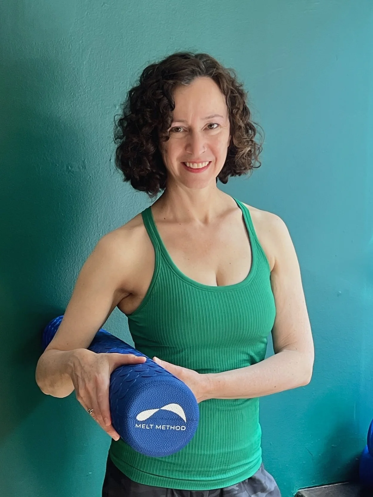 Edya Kalev, Pilates instructor at Hell's Kitchen Pilates, smiling in the studio.