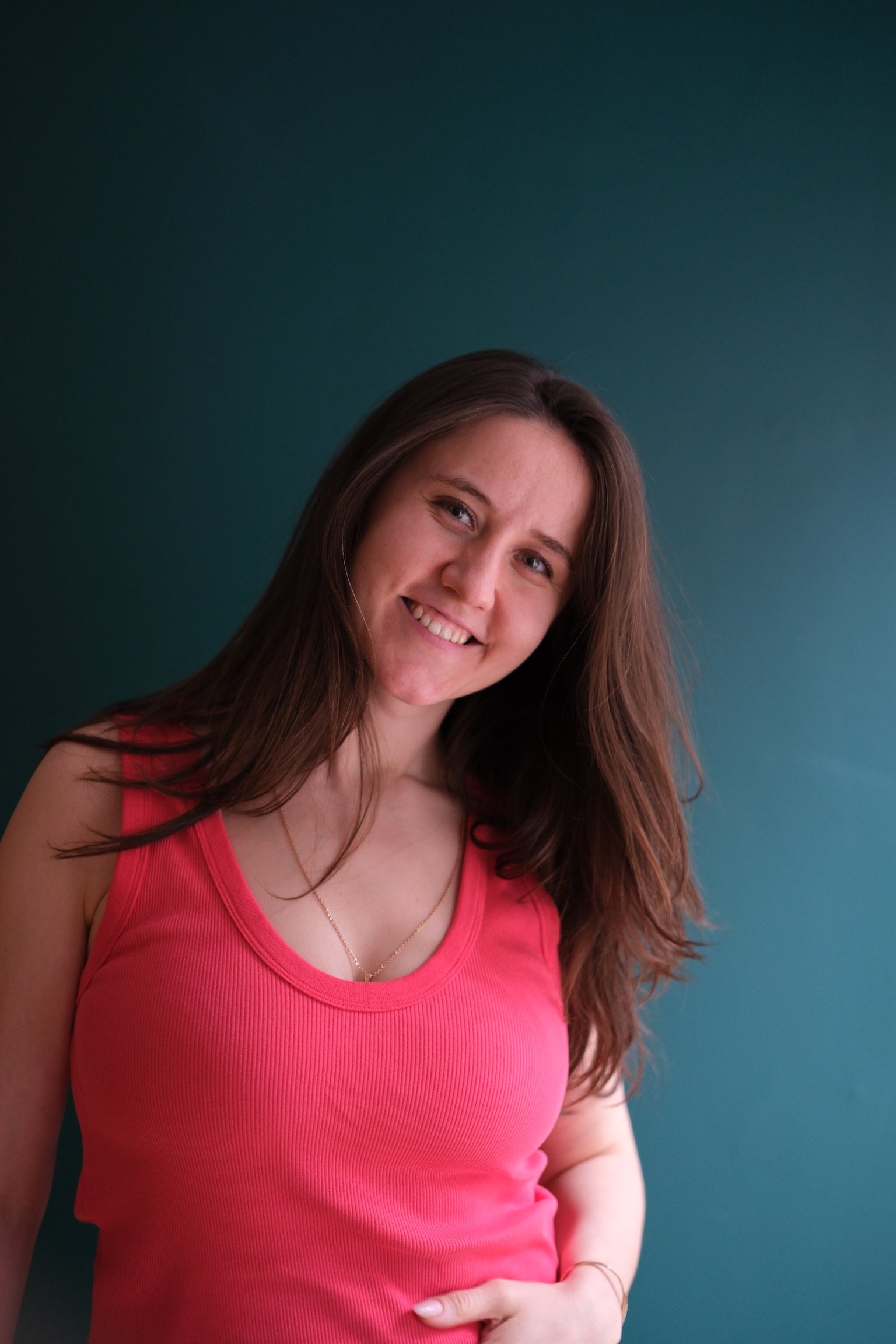 Nadya Kerus, Pilates studio owner at Hell's Kitchen Pilates, smiling in a pink tank top