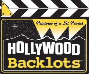 Movie clapboard titled Hollywood Backlots. Searchlights over the nighttime mountains illuminate 'Paintings of a Set Painter'.