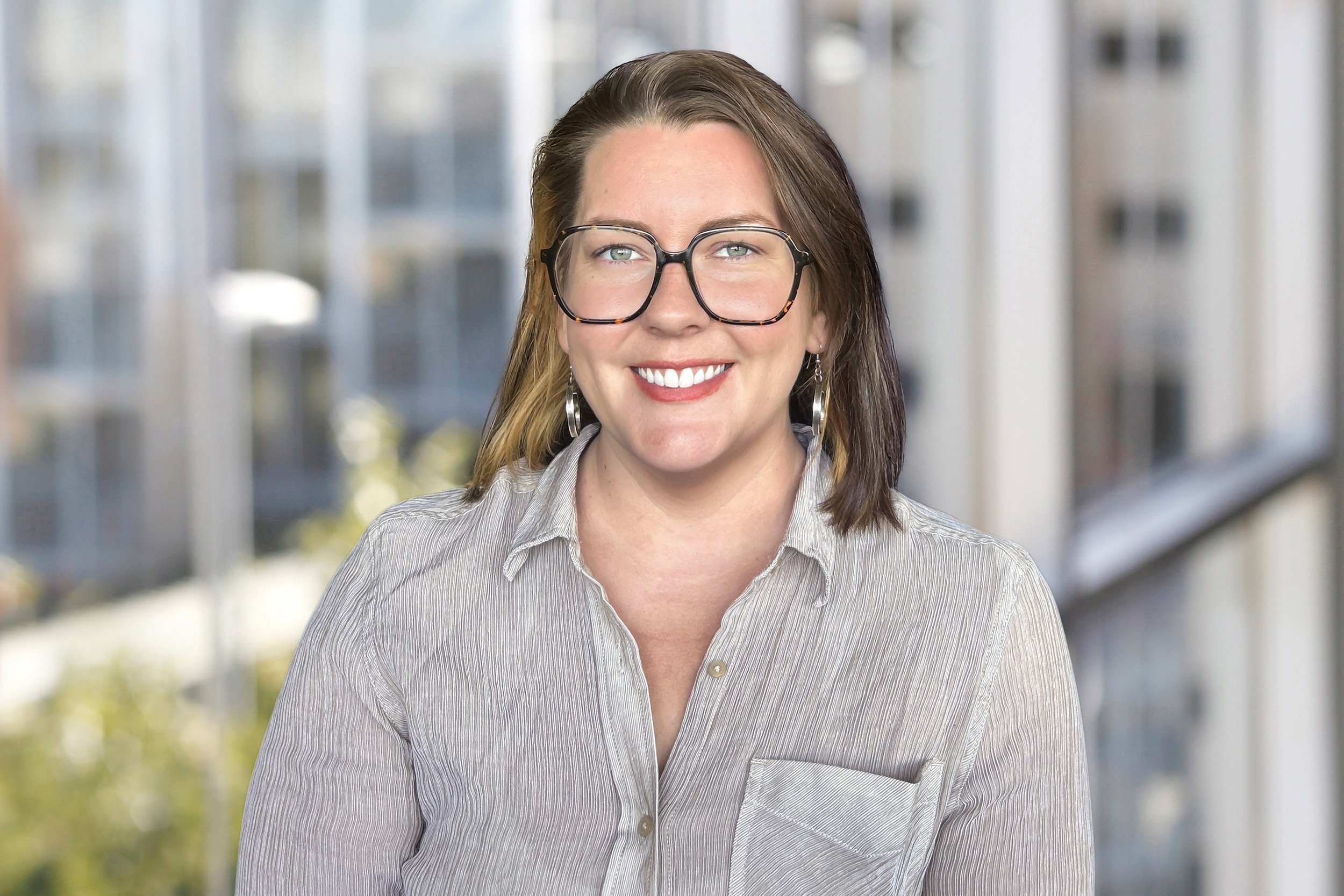 A woman with short hair and glasses.