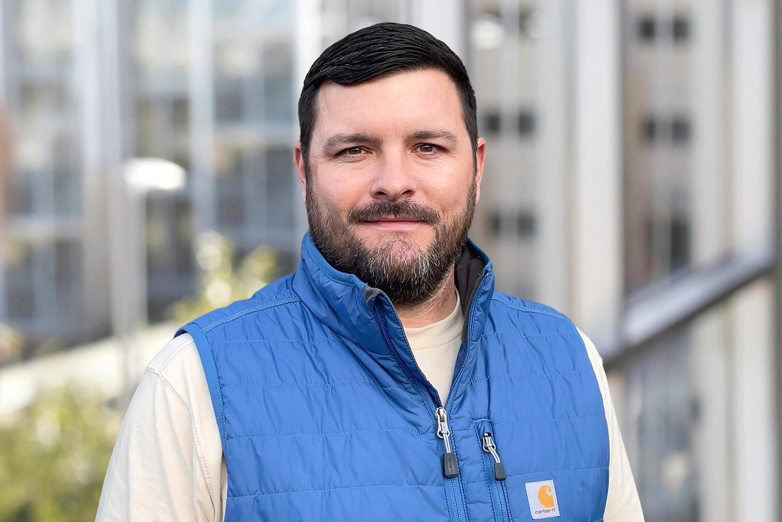 A portrait of a man with short dark hair, a beard.