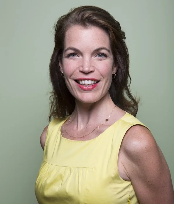 A smiling woman with shoulder-length dark hair.