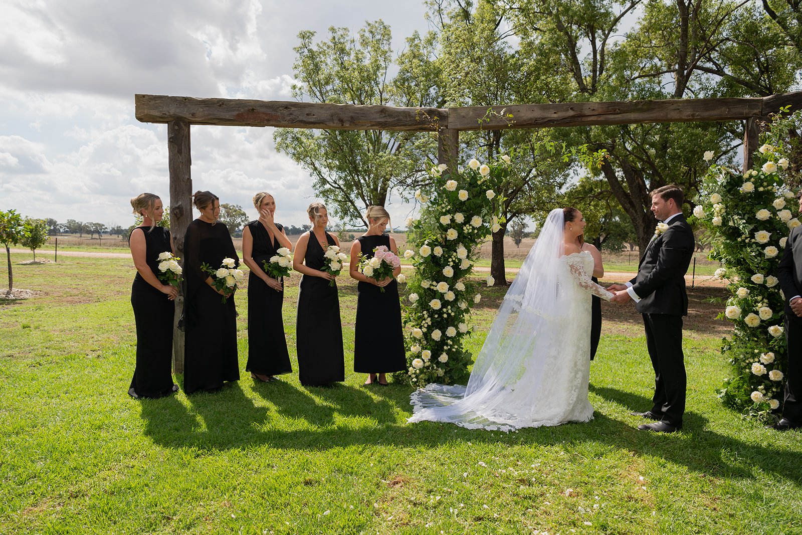 Wedding party standing in front of the beautiful timber arbour in the garden ceremony area at Rawson Park Homestead near Wagga Wagga, NSW.