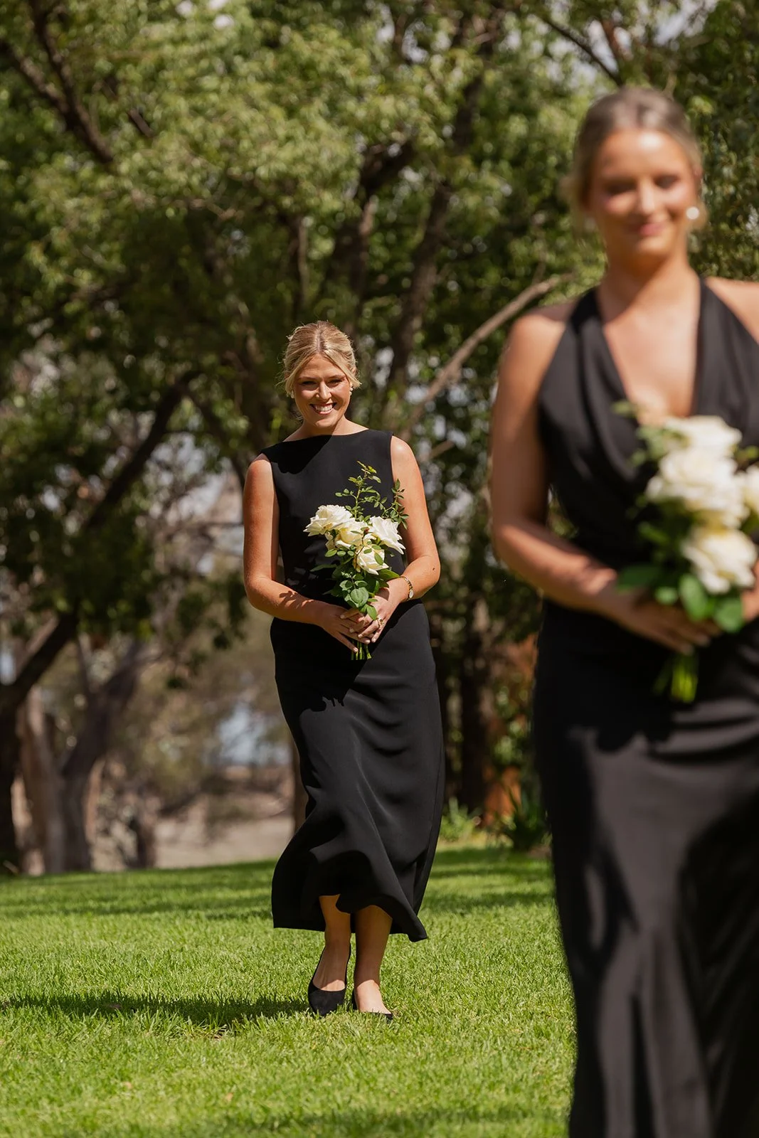 Bridesmaids walking down the aisle through the beautiful garden ceremony area at Rawson Park Homestead near Wagga Wagga, NSW.