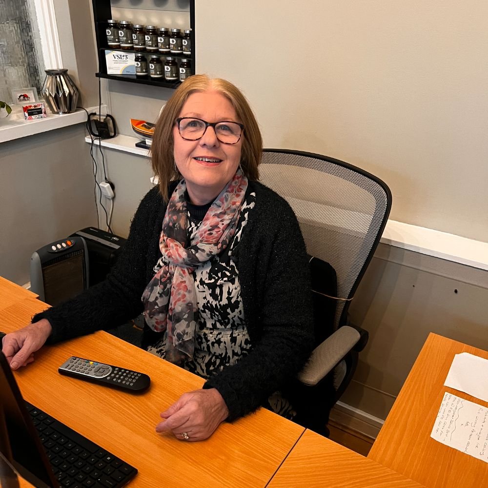 Receptionist sat at the desk at the optimum spine centre