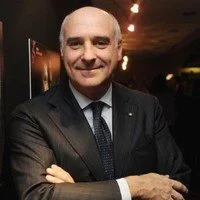 Uomo sorridente in abito elegante in un ambiente interno elegante.