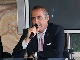 Uomo in abito giacca e cravatta mentre parla al microfono