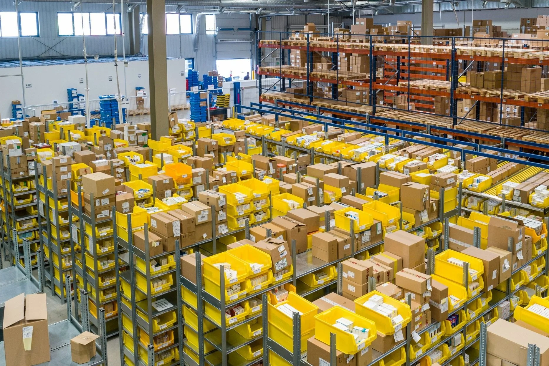 Warehouse with shelves of yellow bins and cardboard boxes