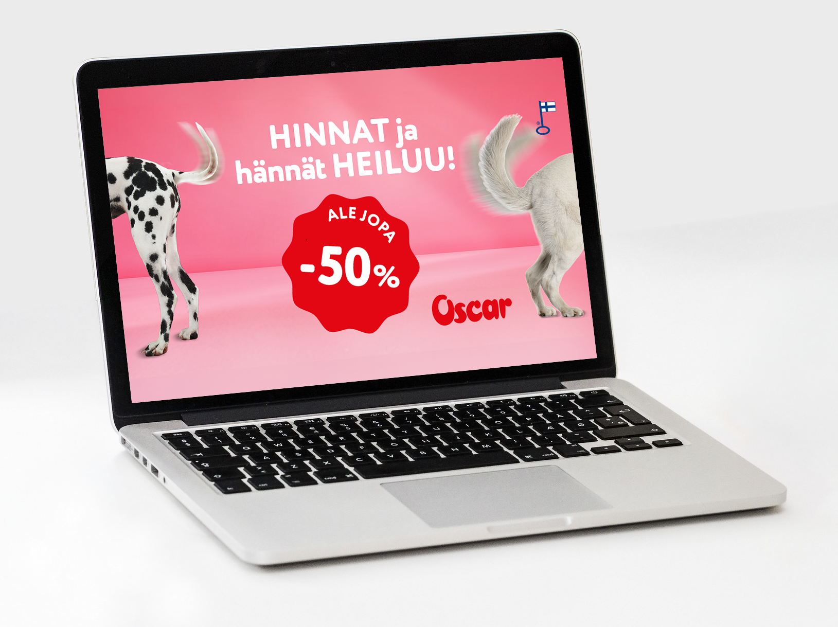 Kannettava tietokone näytöllä on mainos, jossa on kaksi koiran takapuolta ja hännät. Siinä on trksti, joka mainostaa alennuksia. Taustaväri on vaaleanpunainen.