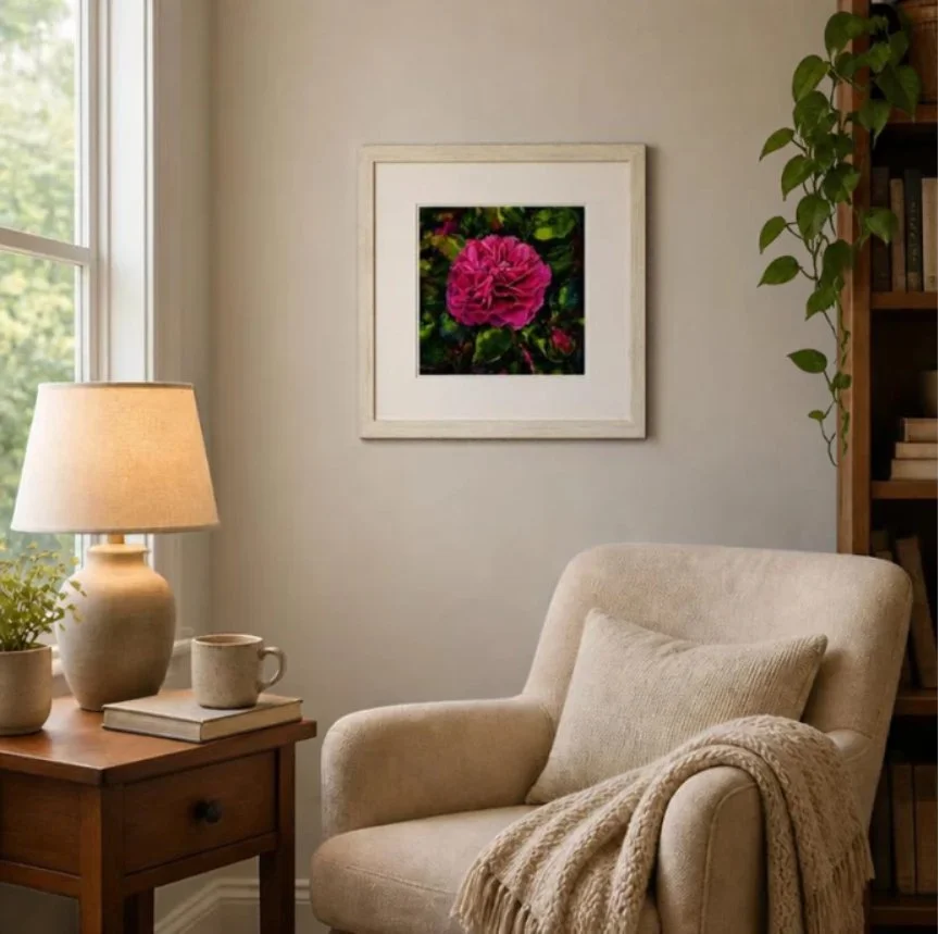 Cosy room with a framed print of a vibrant pink Gabriel Oak David Austin rose with deep green leaves
