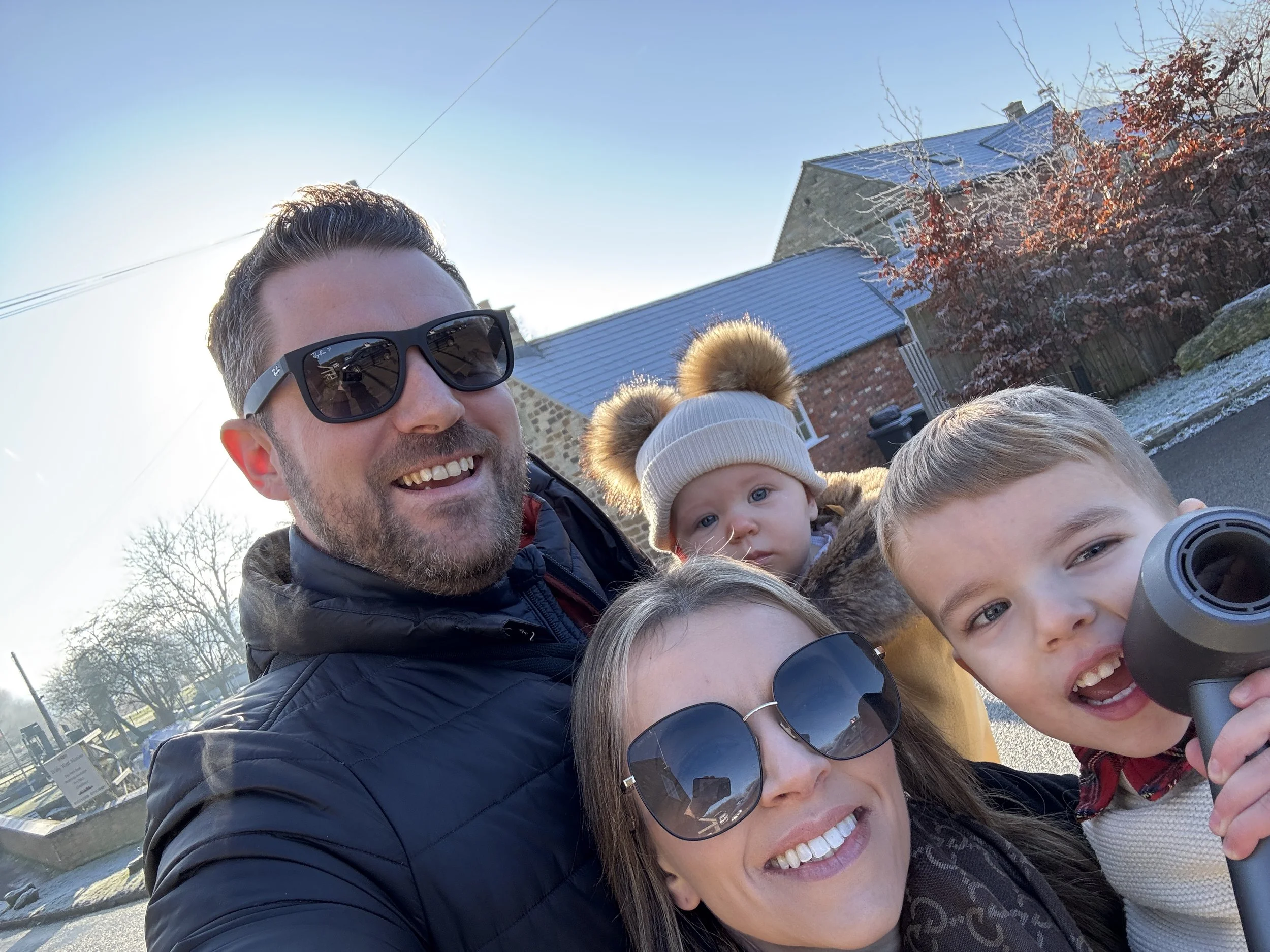 Photo of Alex, co-founder of Adult Proof, with his wife and two children on a cold British sunny day.