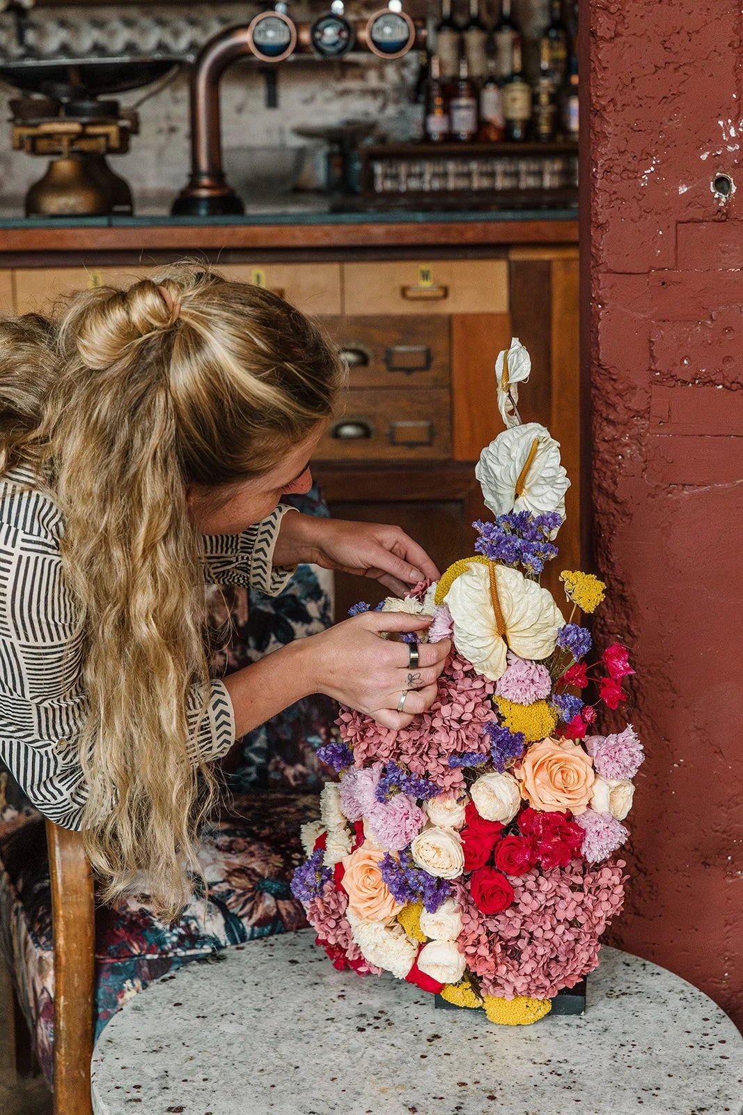 Arranging flowers in a preserved flower centrepiece