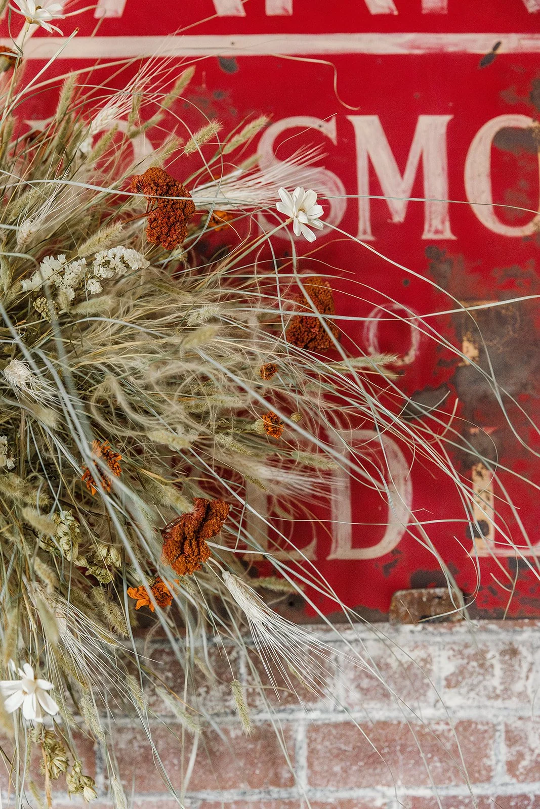 Close up of natural dried flower hanging with vintage sign in the background