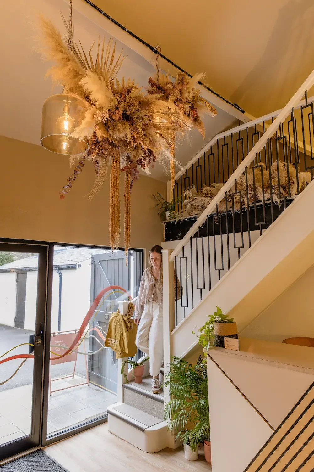 Full view of dried botanical ceiling installation wrapping existing pendant lighting in the reception at Life and Lemons Clinic, Sheffield