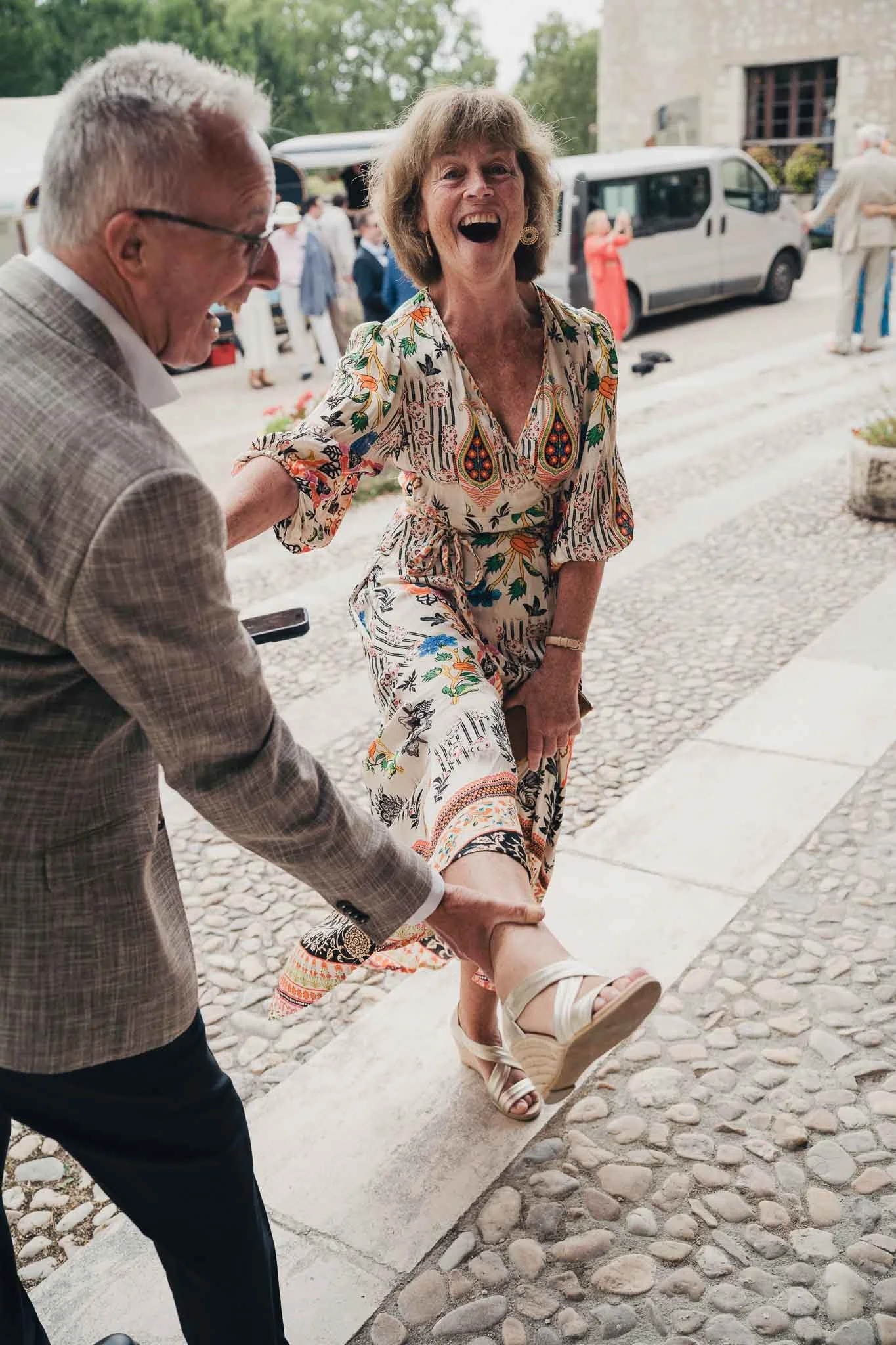 Guest stepping out of a car and greeting another guest on arrival at the wedding.