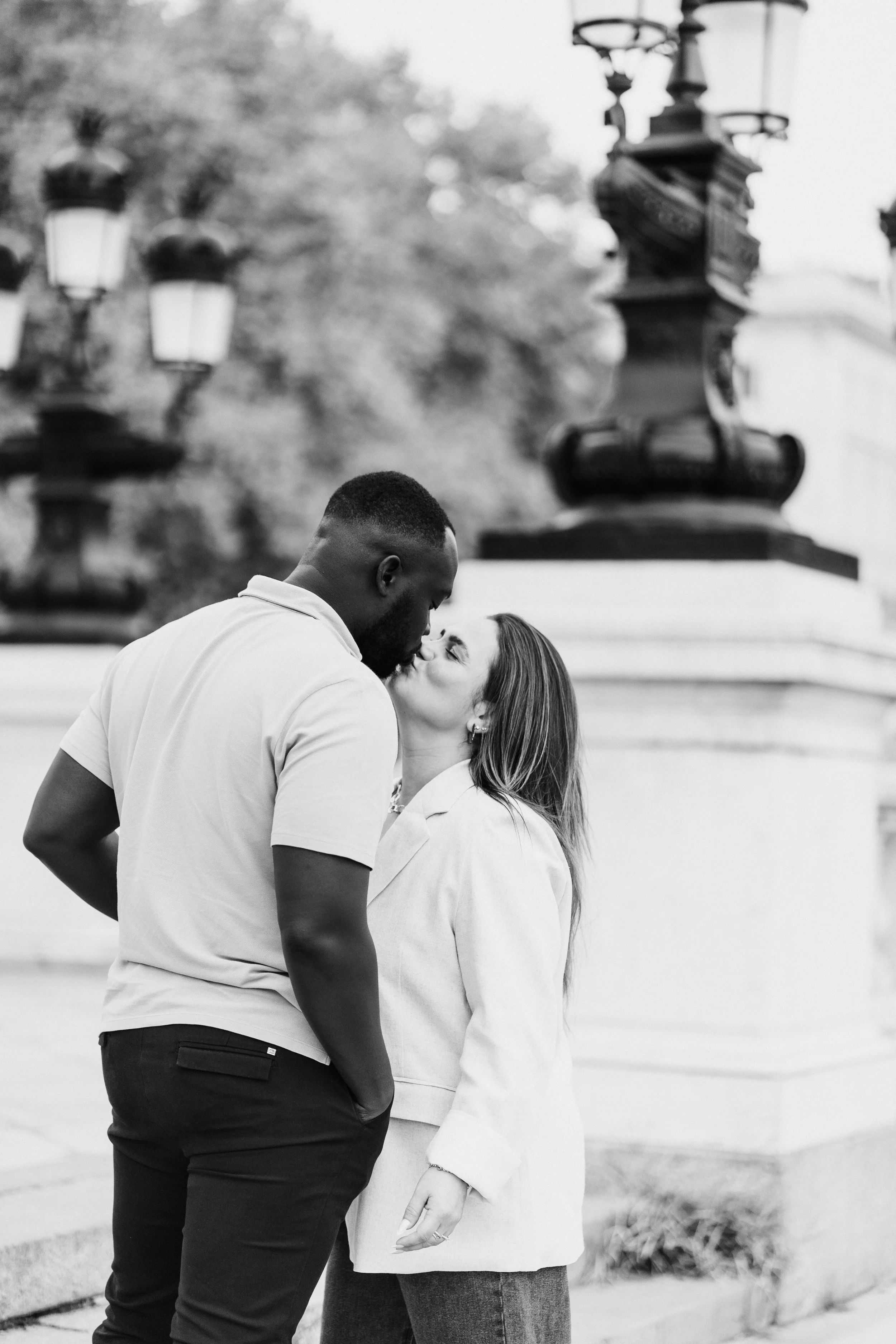 Black and white image of couple sharing a kiss moments after getting engaged in Bordeaux.