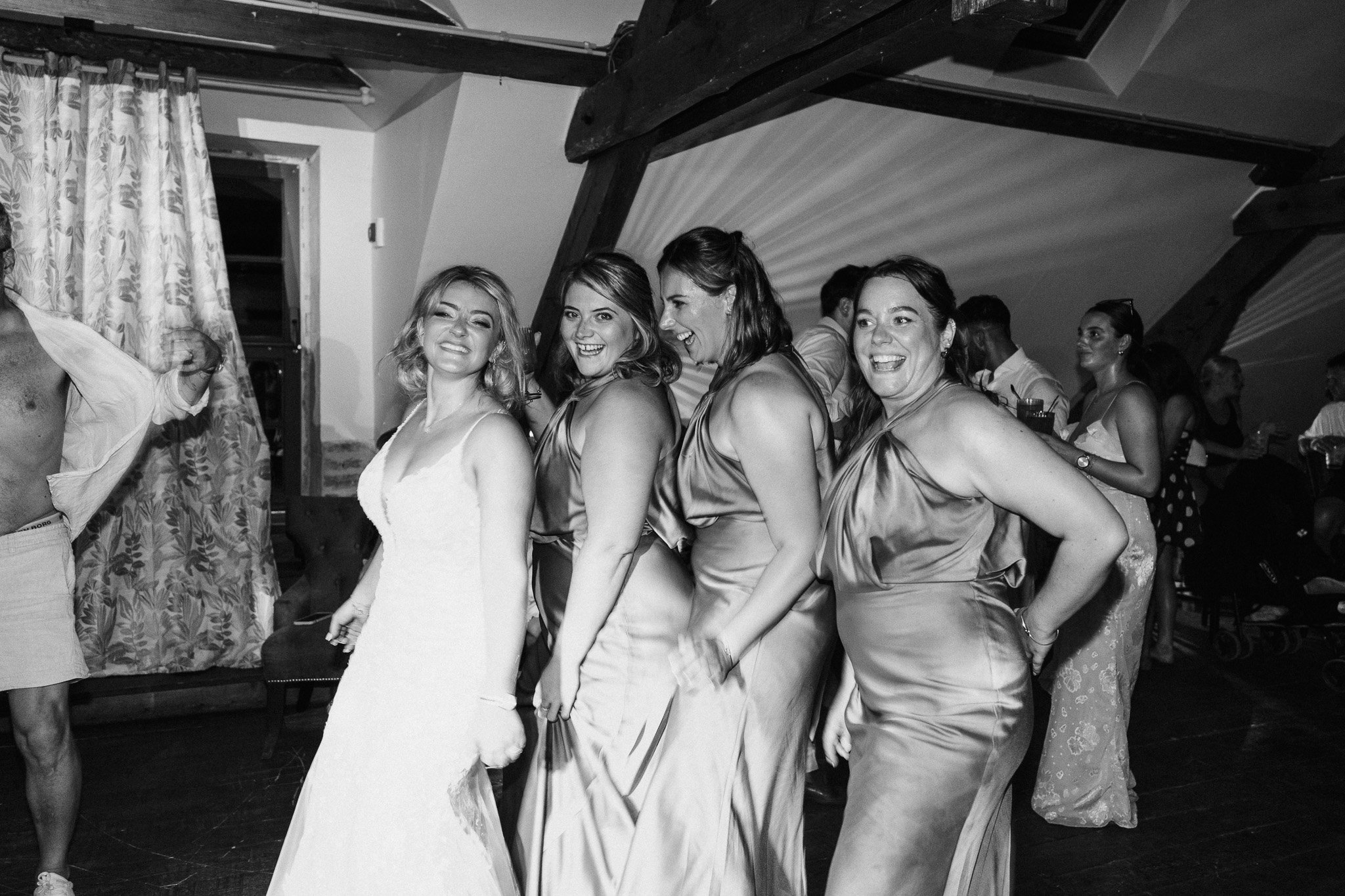 Bridesmaids posing together in a candid moment during the evening wedding celebrations.