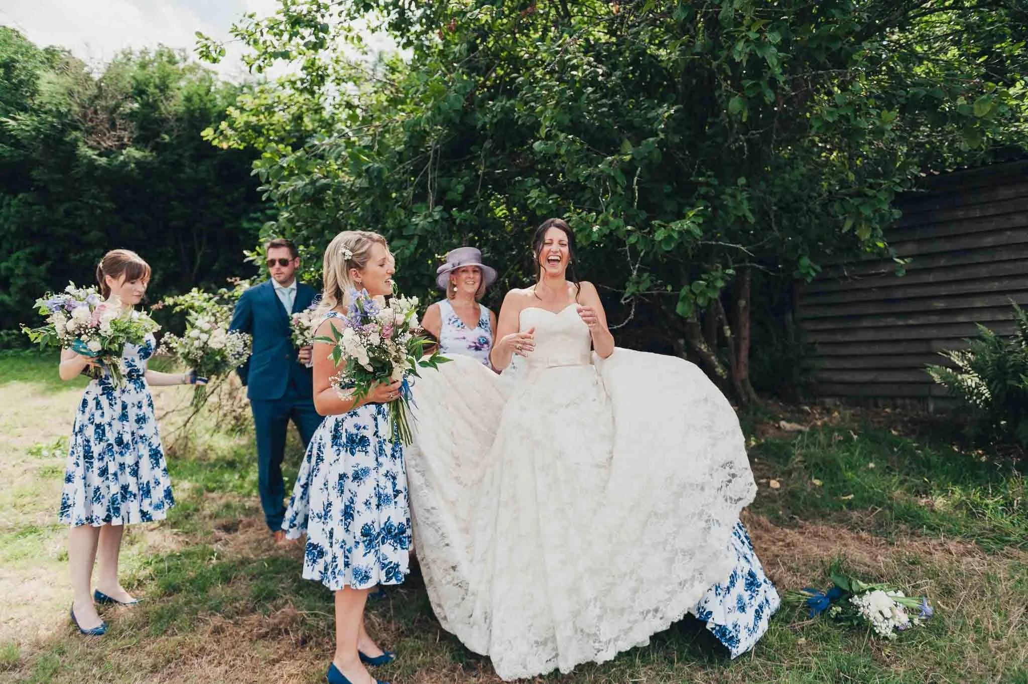 The bride and bridesmaids arriving at the outdoor ceremony area with the groom and guests waiting nearby.