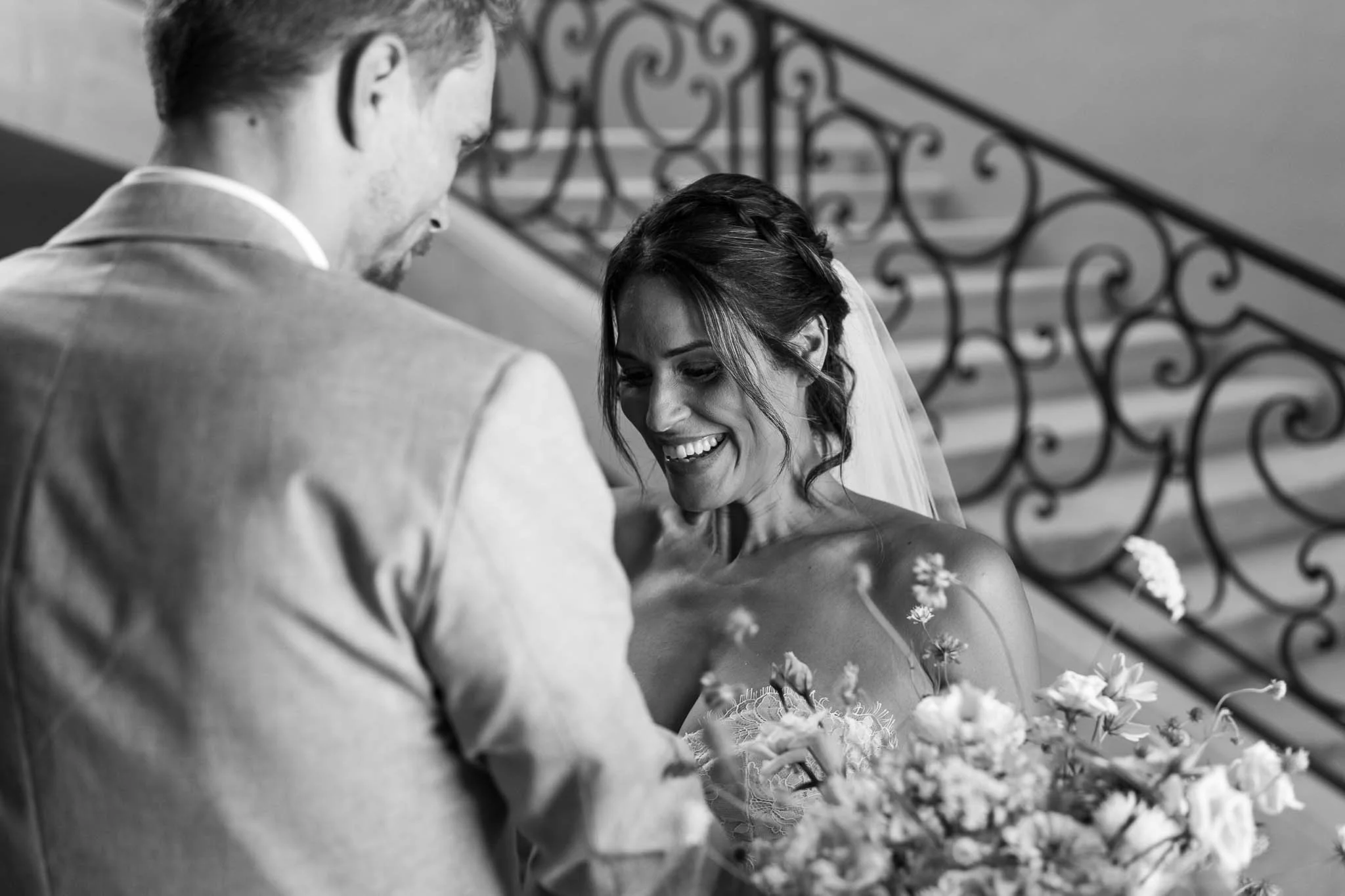 Black and white close portrait of bride and groom on the staircase at Château de Sainte Croix, Dordogne