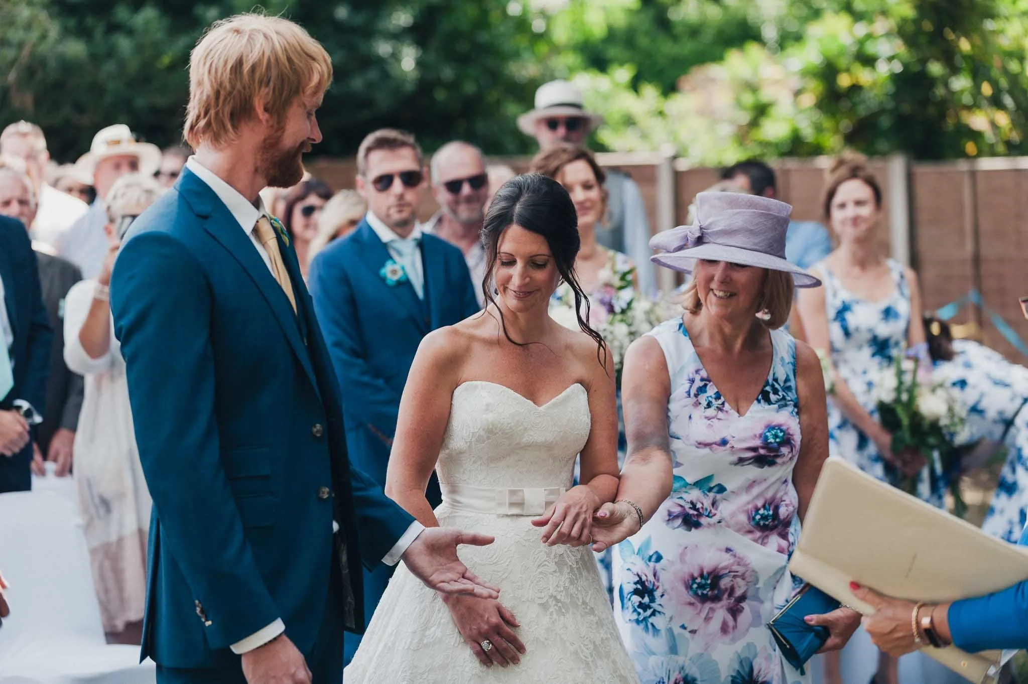 The bride standing with her escort while the groom looks on during the start of the ceremony.