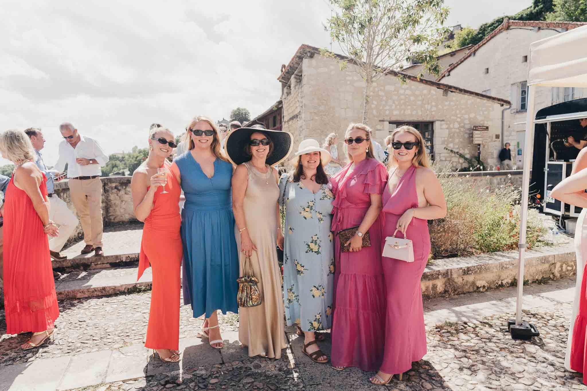Group of wedding guests posing for a photo in the courtyard at Manoir de Longeveau.