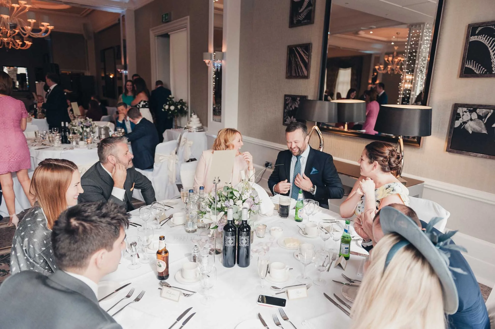 Guests chatting around a decorated table during the wedding breakfast at Richmond Hill Hotel.