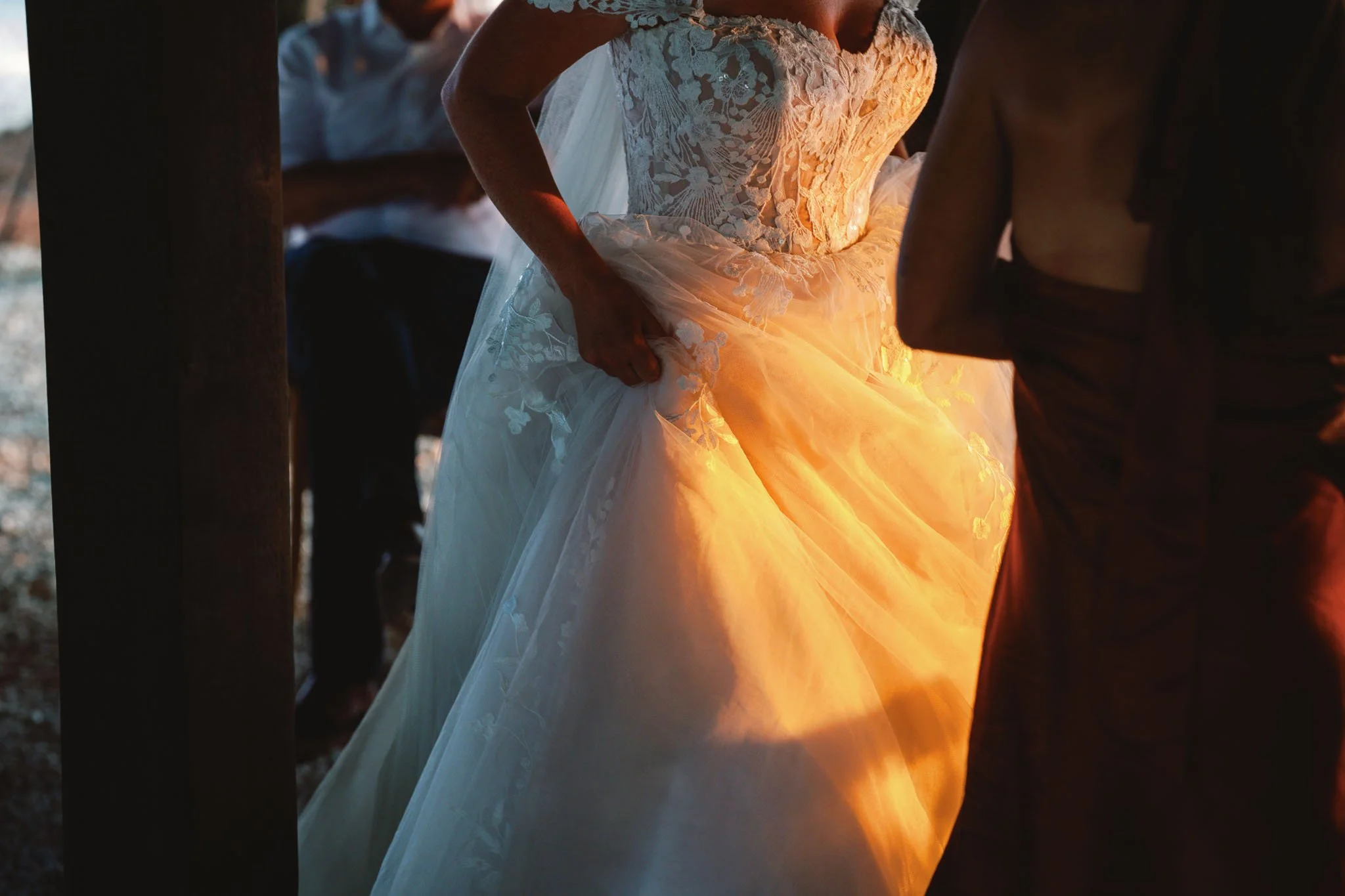 Bride in wedding dress with golden light filtering through fabric, Southwest France wedding photography