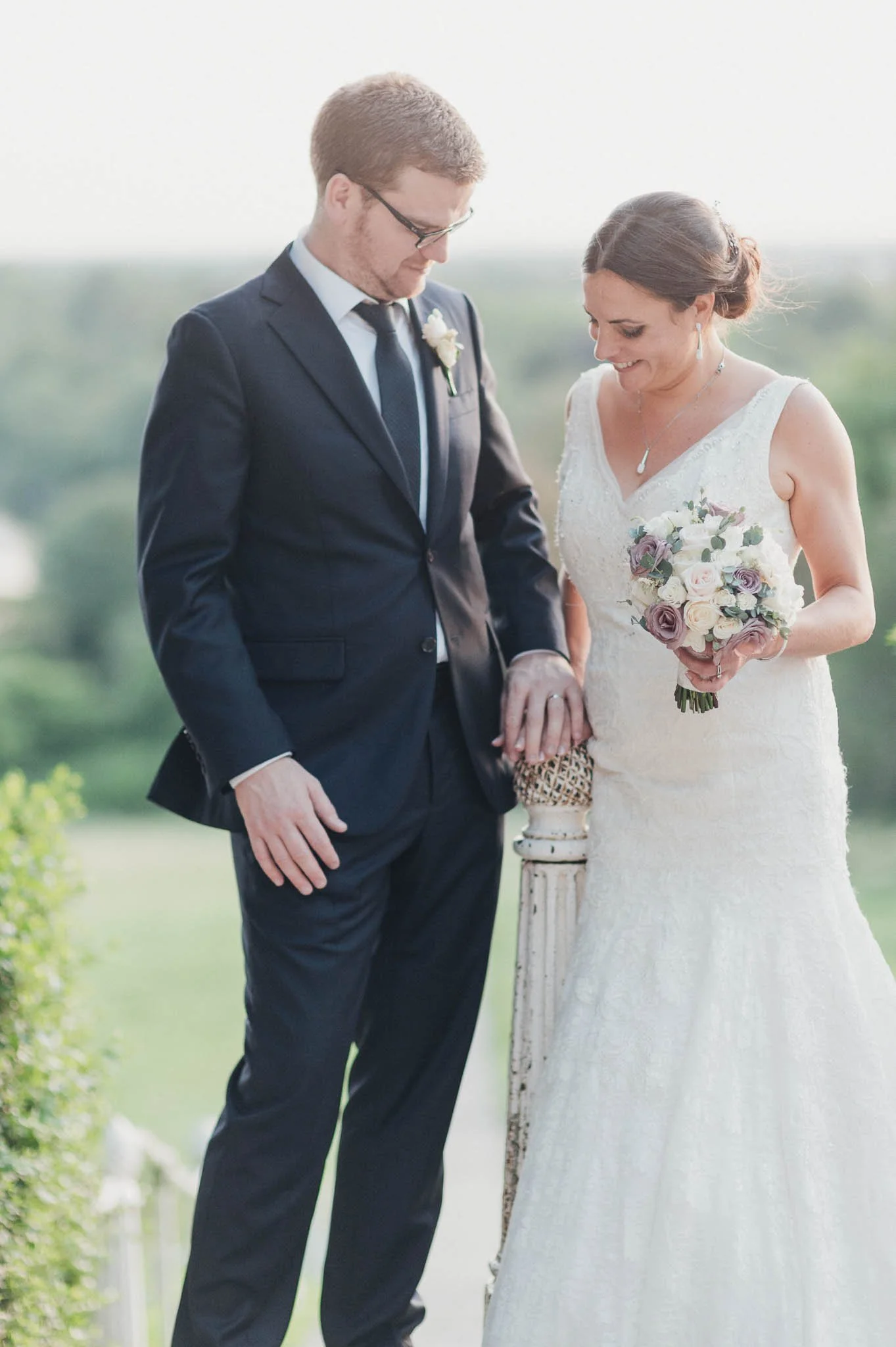 The couple walking hand-in-hand looking at the grooms ring.