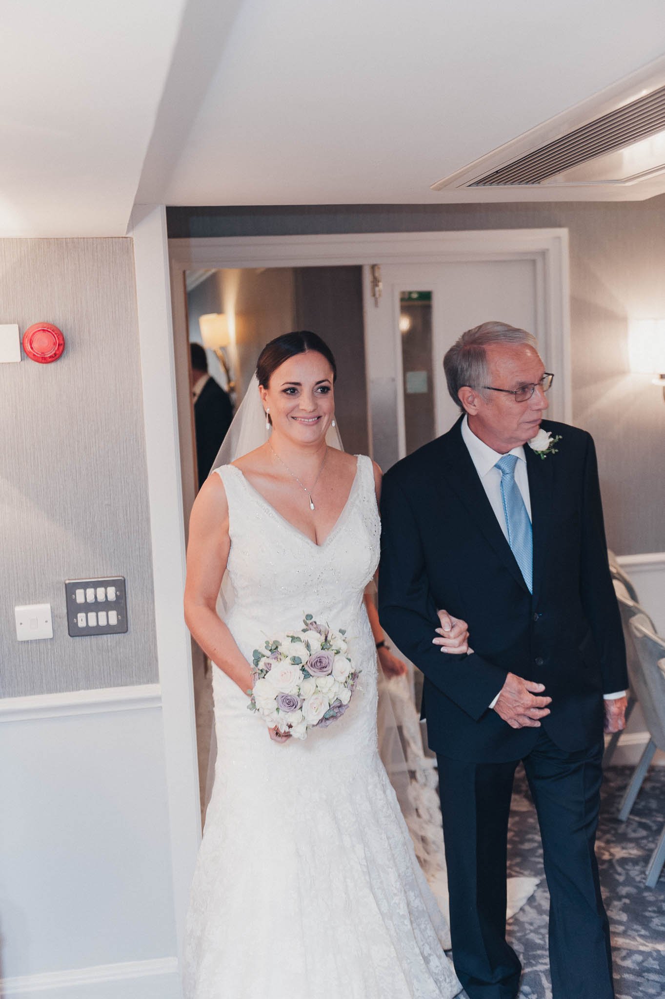 Bride walking down the hallway with a family member before the ceremony begins.