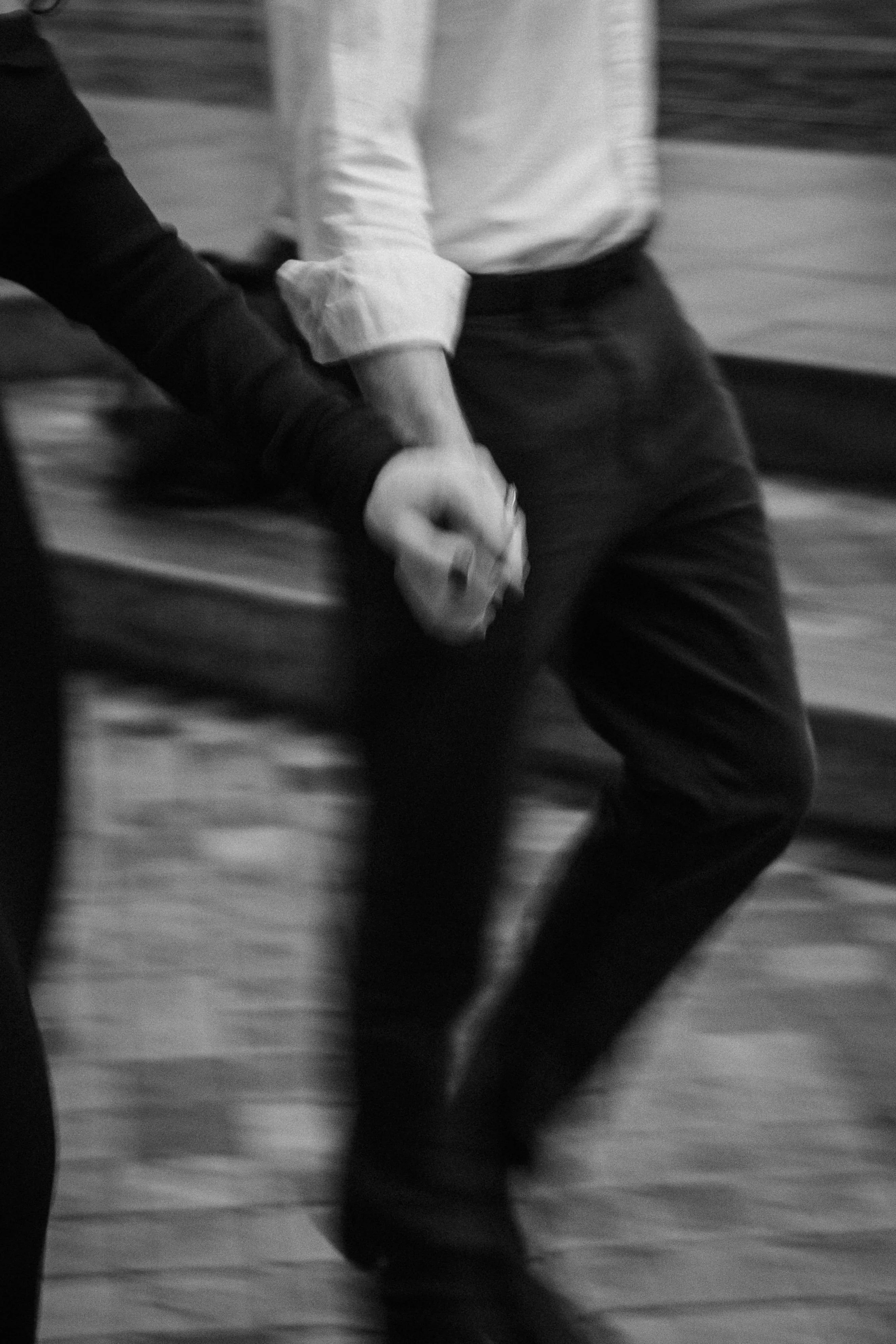 Motion-blurred photograph of engaged couple walking hand in hand through Bordeaux streets.