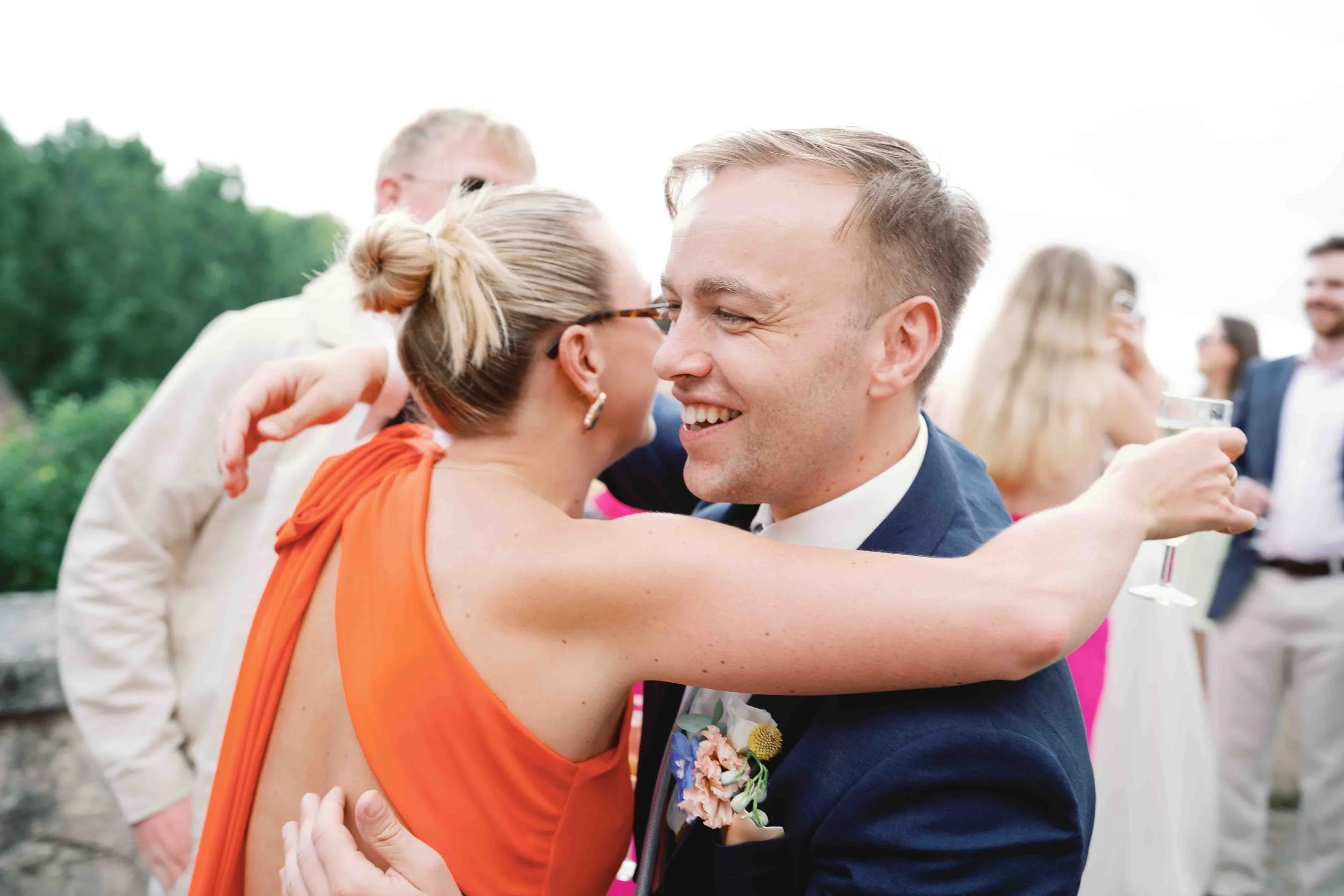 A guest hugging the groom during a relaxed part of the wedding day, showing the atmosphere after the formal moments have passed.
