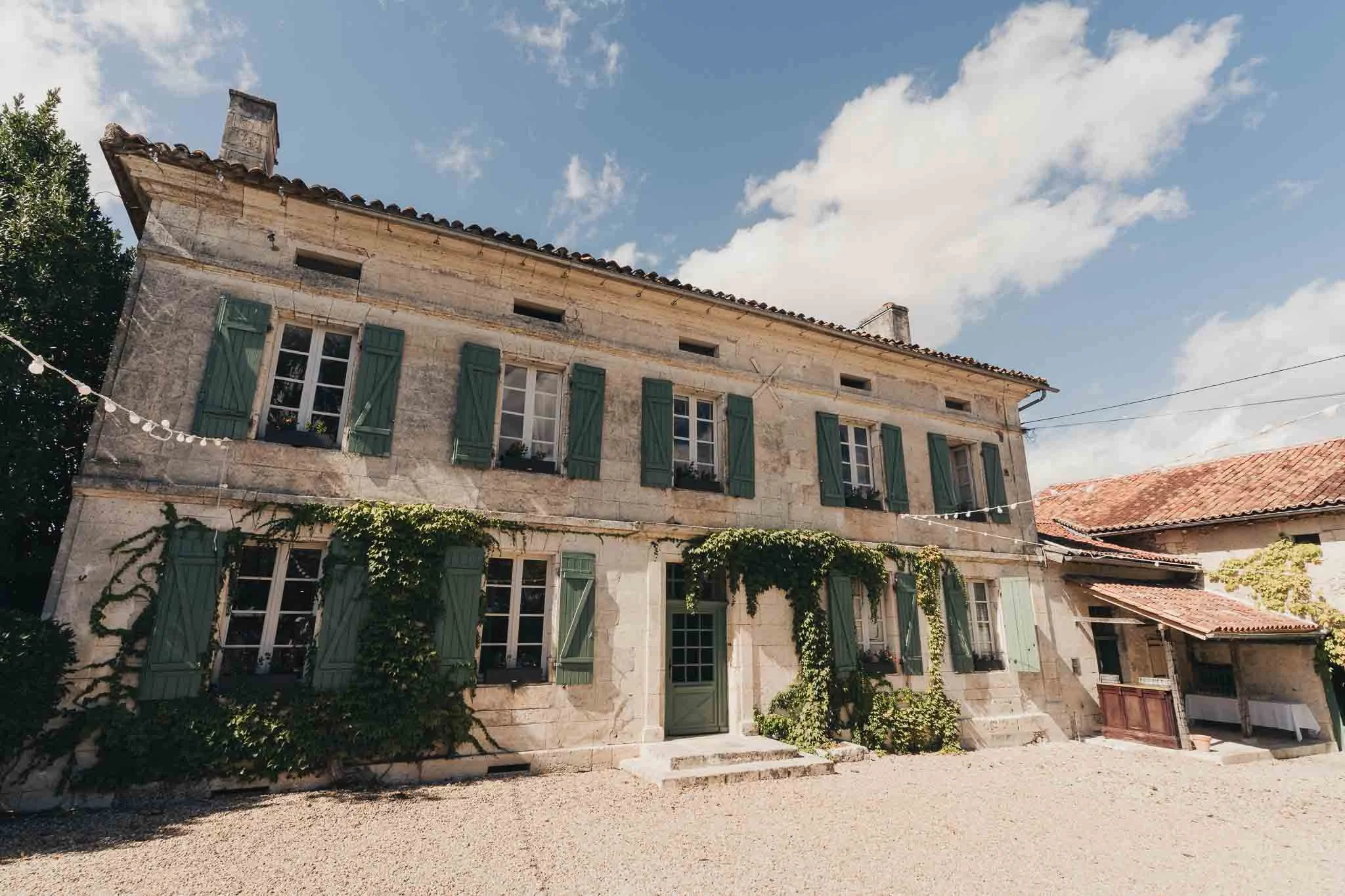 Exterior of Manoir de Longeveau on a sunny afternoon with ivy climbing the walls.