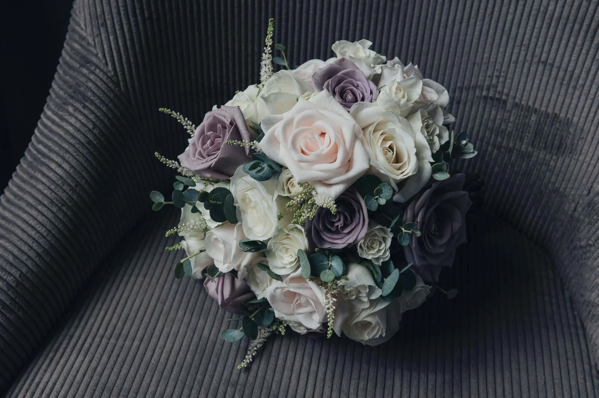 A pastel rose bridal bouquet resting on a chair.