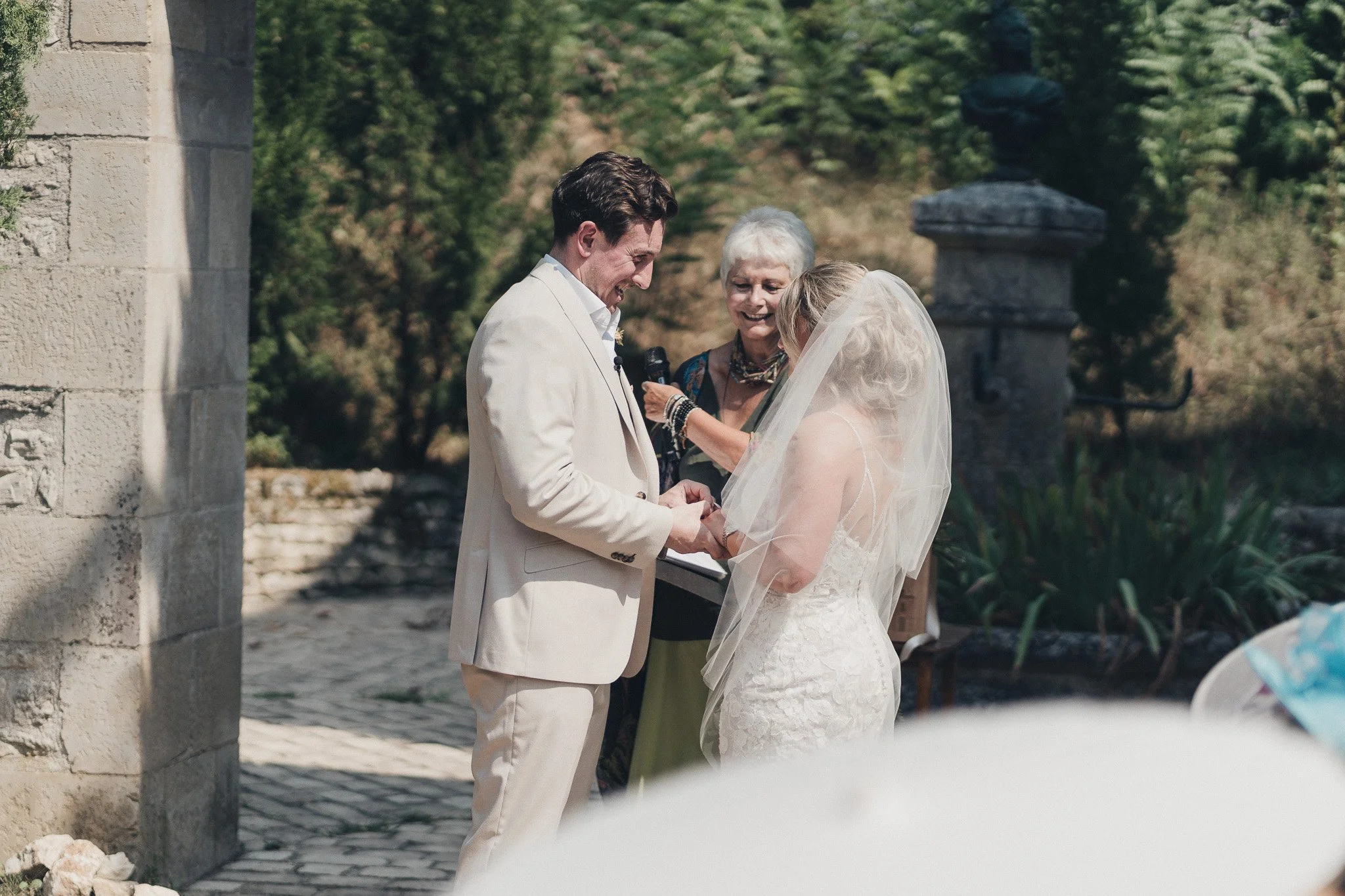 Couple exchanging vows during their outdoor wedding ceremony at a château in southwest France.