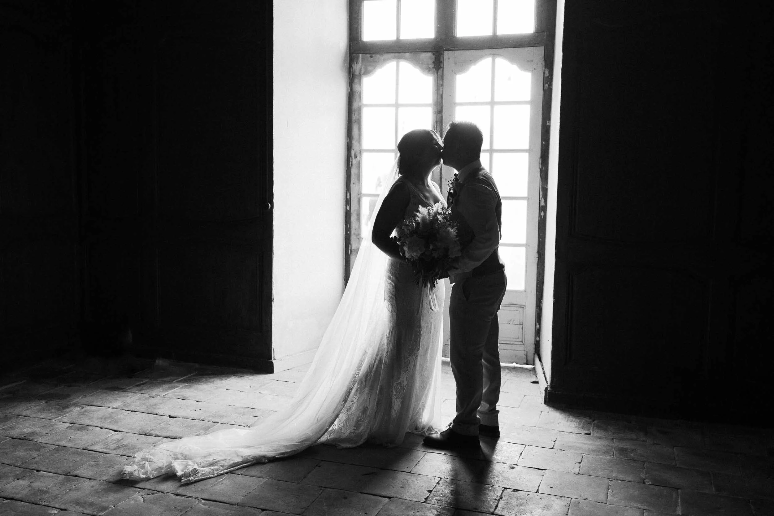 Silhouette of bride and groom in a dark doorway at Château de Panisseau, Dordogne