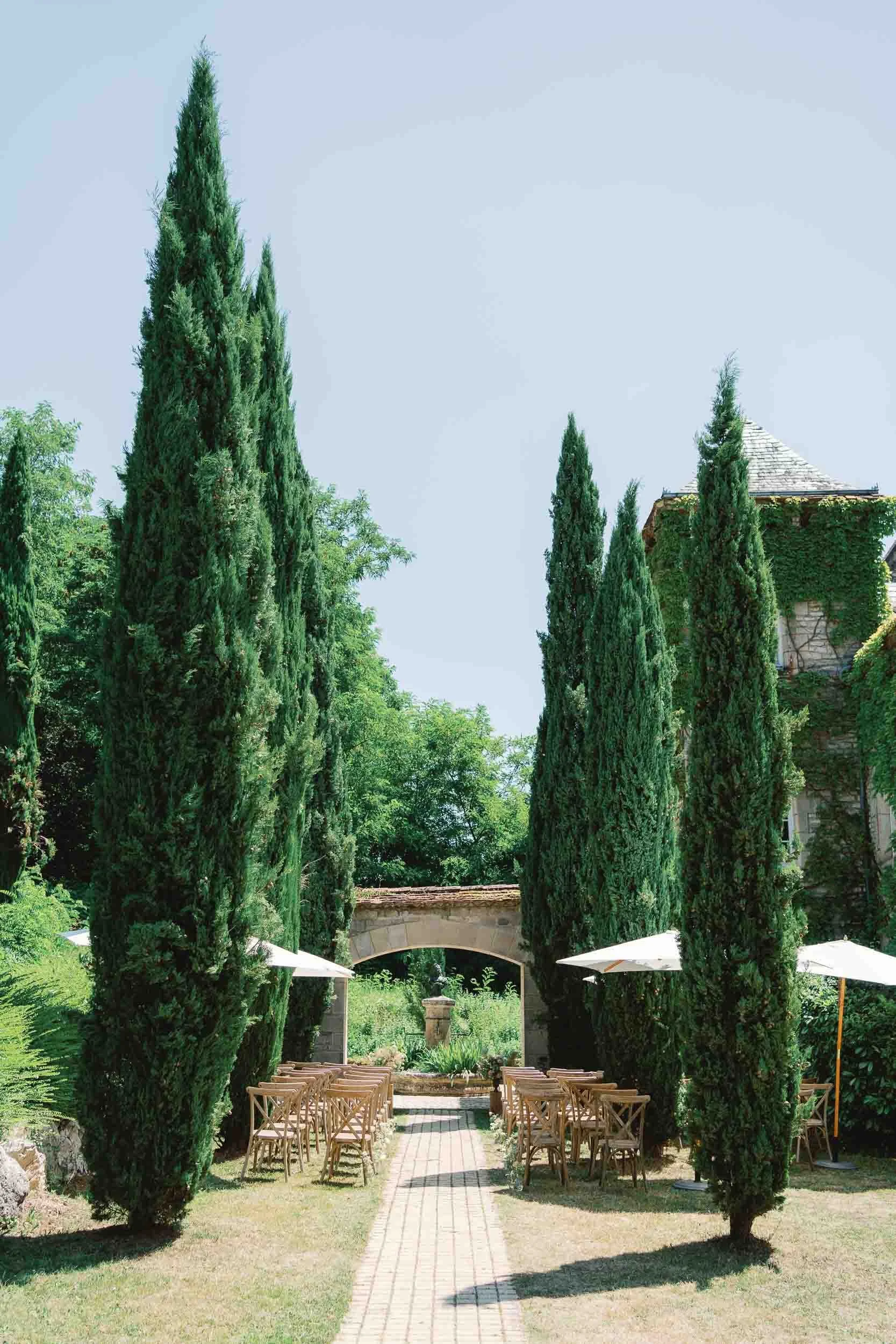 Cypress-lined ceremony aisle at Château du Raysse, Dordogne