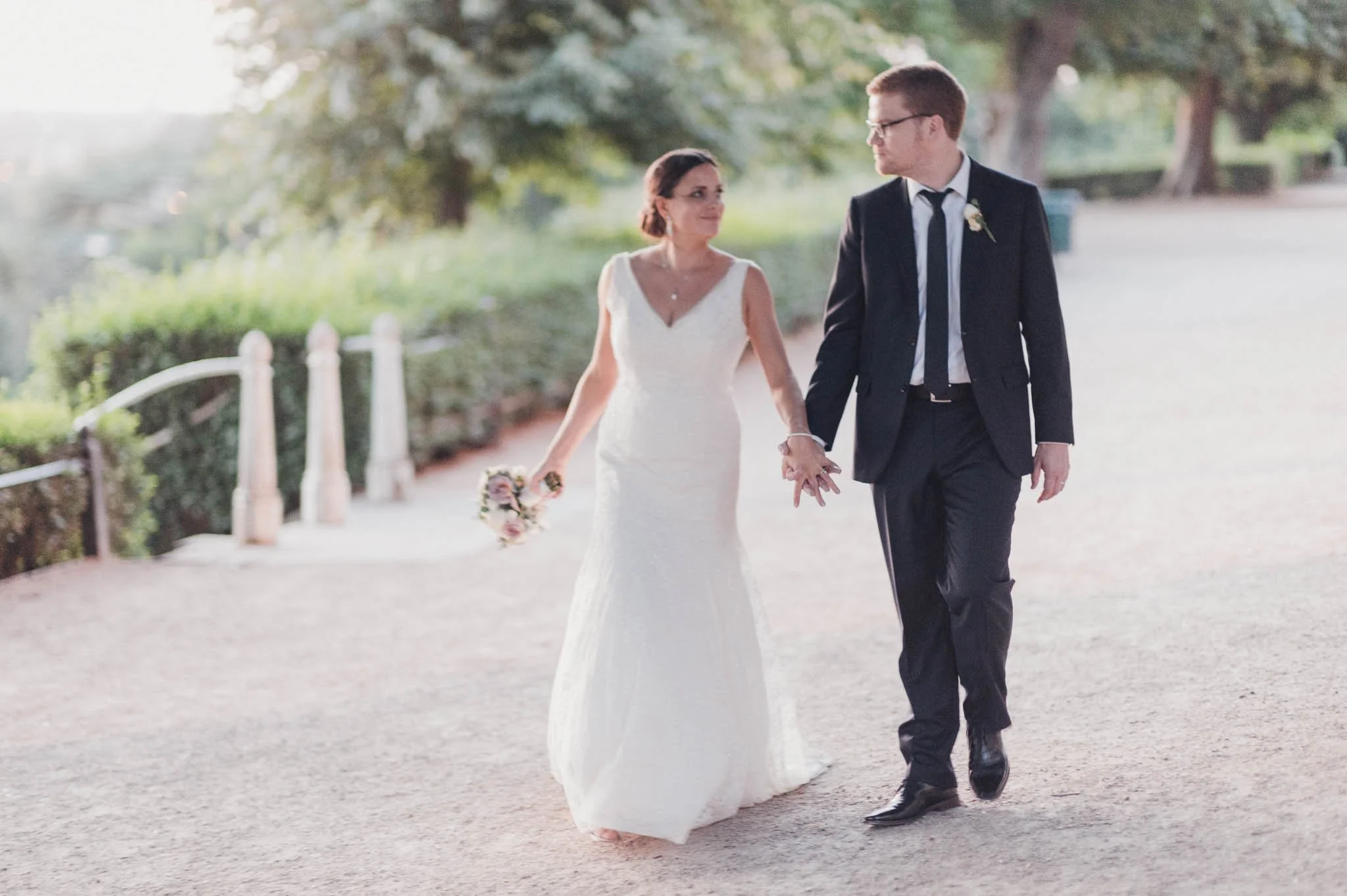 The couple walking hand in hand along a garden path after the ceremony.