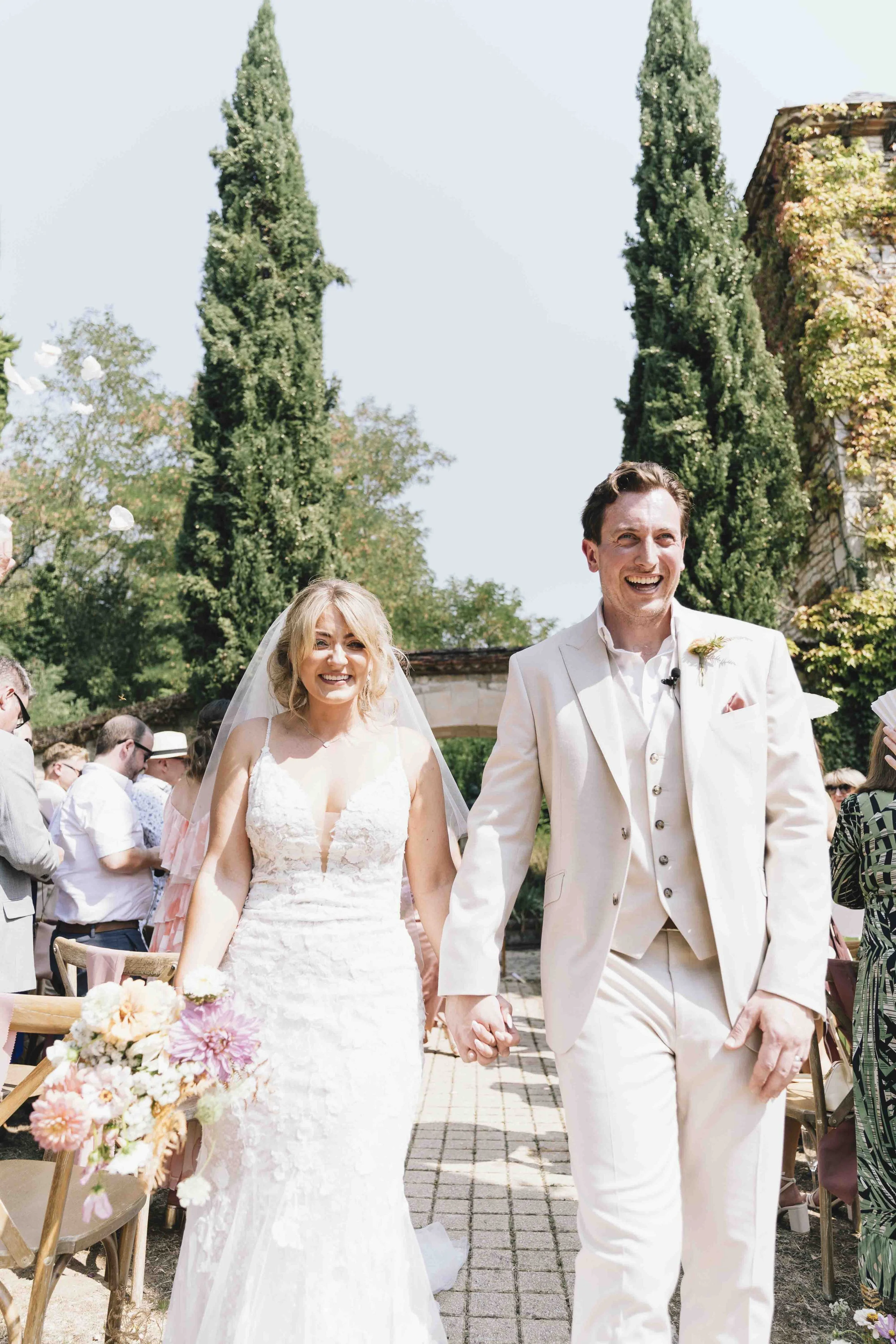 Bride and groom walking down the aisle just married at their château wedding in the Dordogne, France