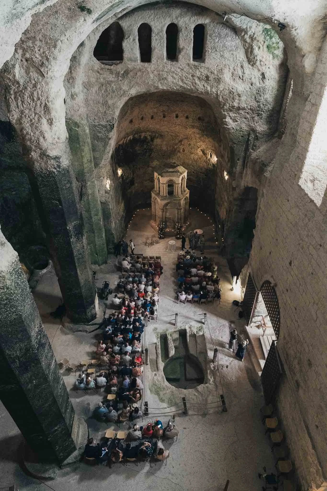 Wide overhead view of the ceremony setup inside the Église Souterraine Saint-Jean in Aubeterre-sur-Dronne.