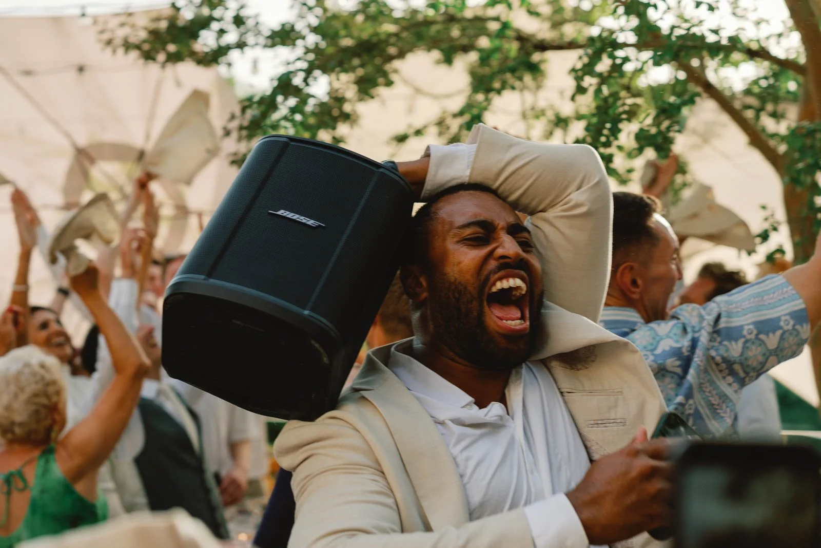 The MC carrying a speaker on his shoulder through the wedding guests at Château Lagorce, Bordeaux