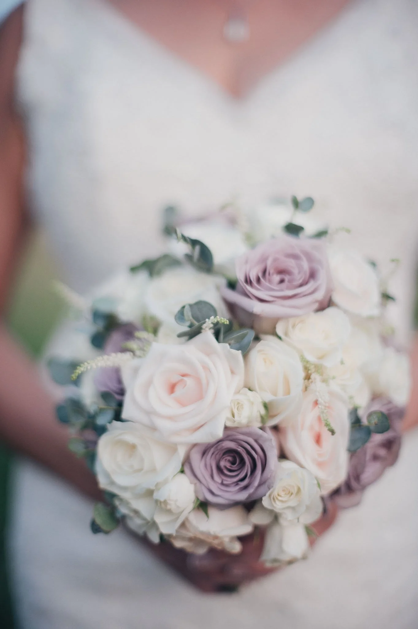 Close-up of the bride holding her pastel rose bouquet.