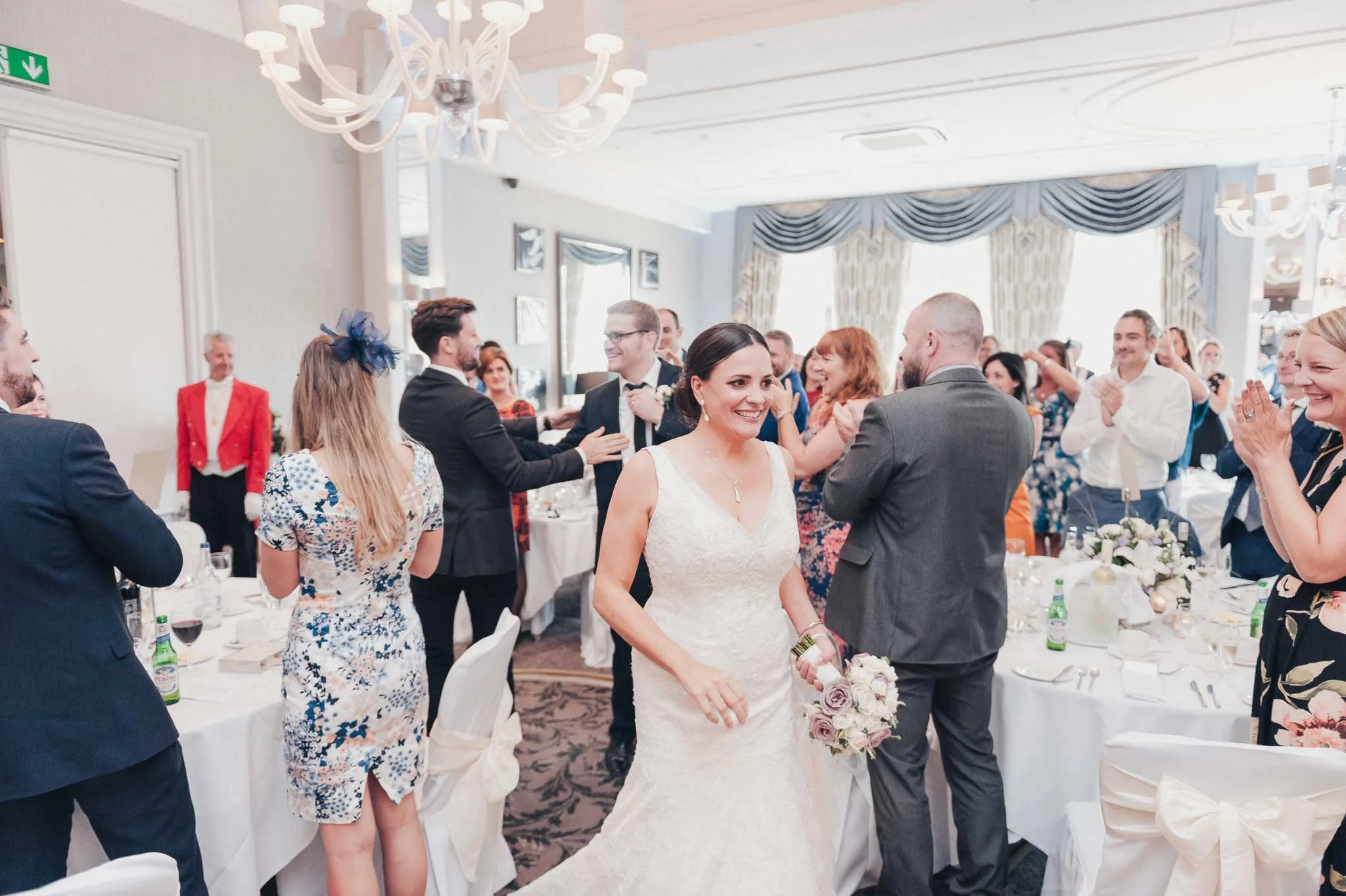 Bride and groom entering the wedding breakfast room at Richmond Hill Hotel, greeted with applause from their guests.