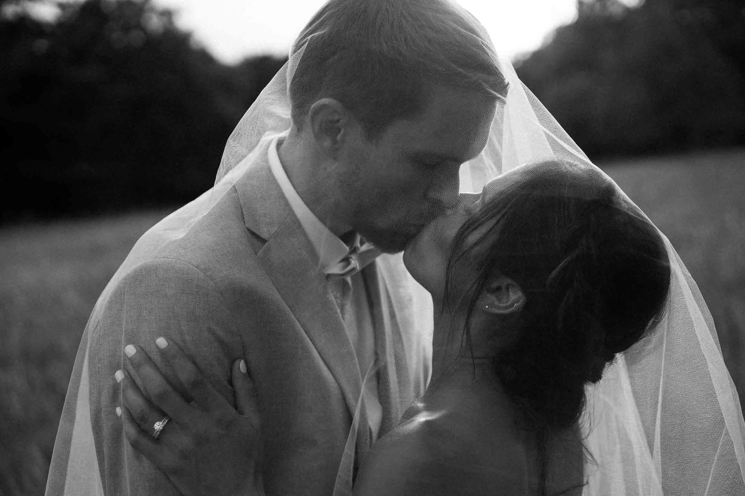 Black and white portrait of bride and groom, foreheads touching, at Château de Sainte Croix, Dordogne