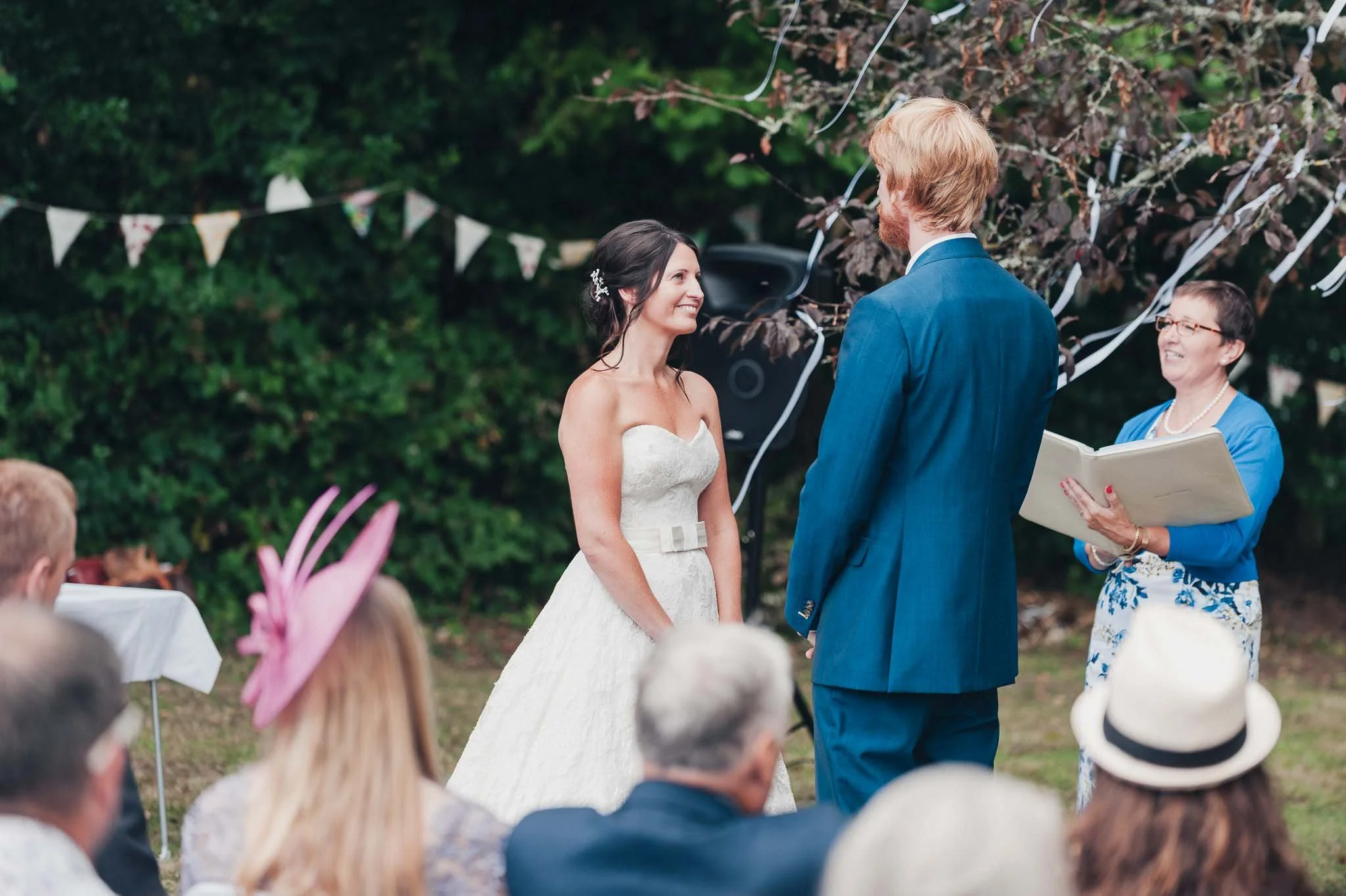 The bride and groom standing together during the ceremony as the celebrant reads.